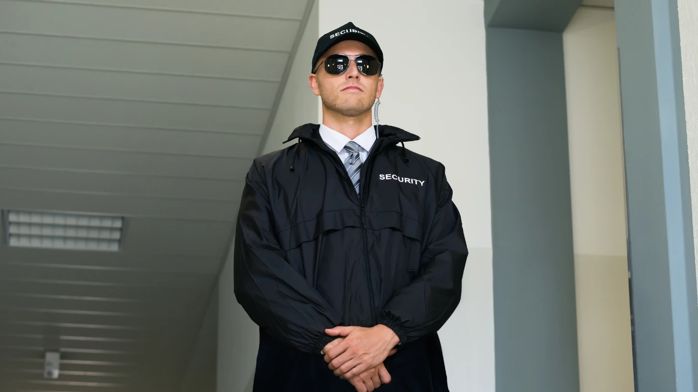 Private security professional stationed at the entrance of a luxury residence.