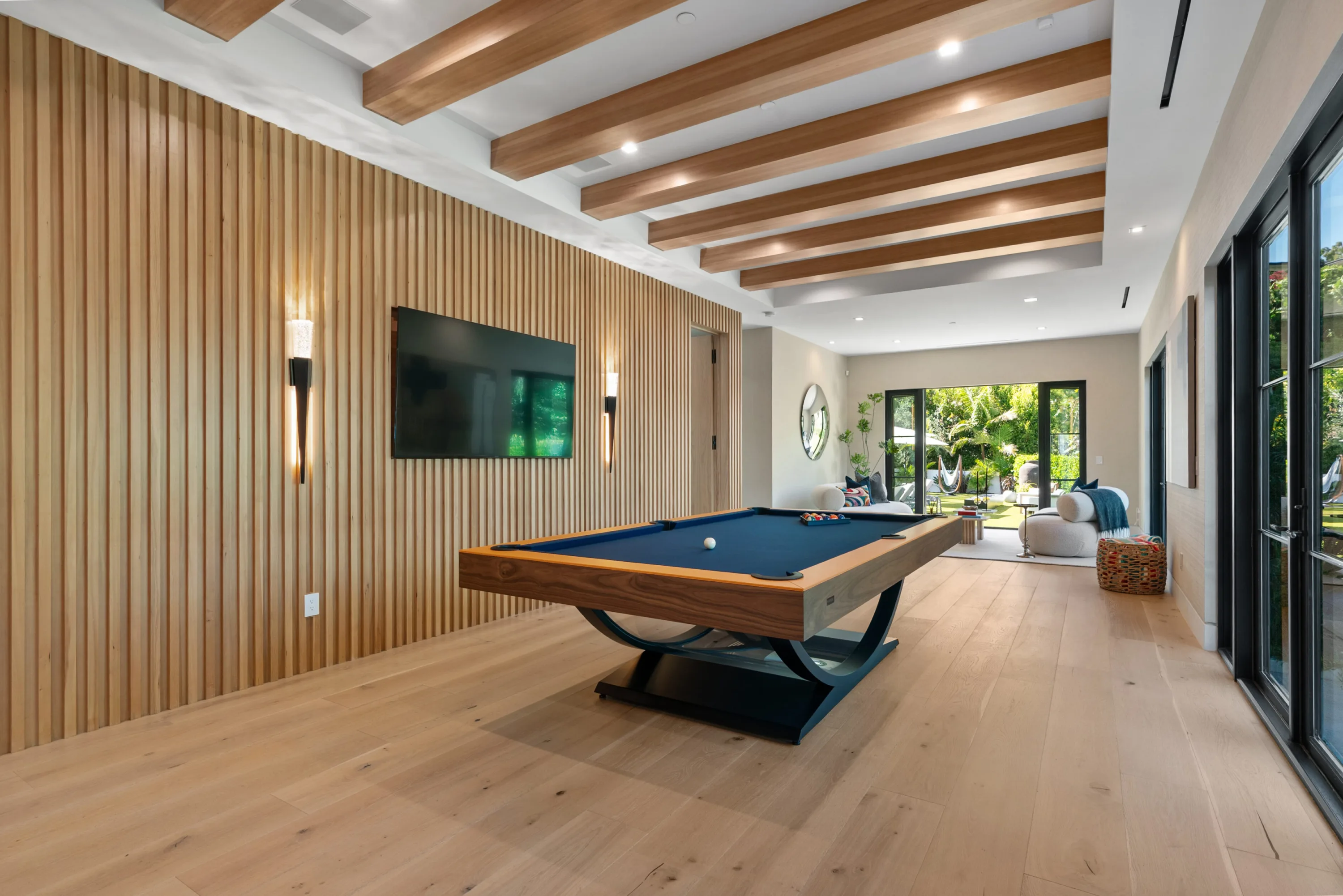 Games room with blue-felt pool table, beamed ceiling and doors opening to the garden seating area