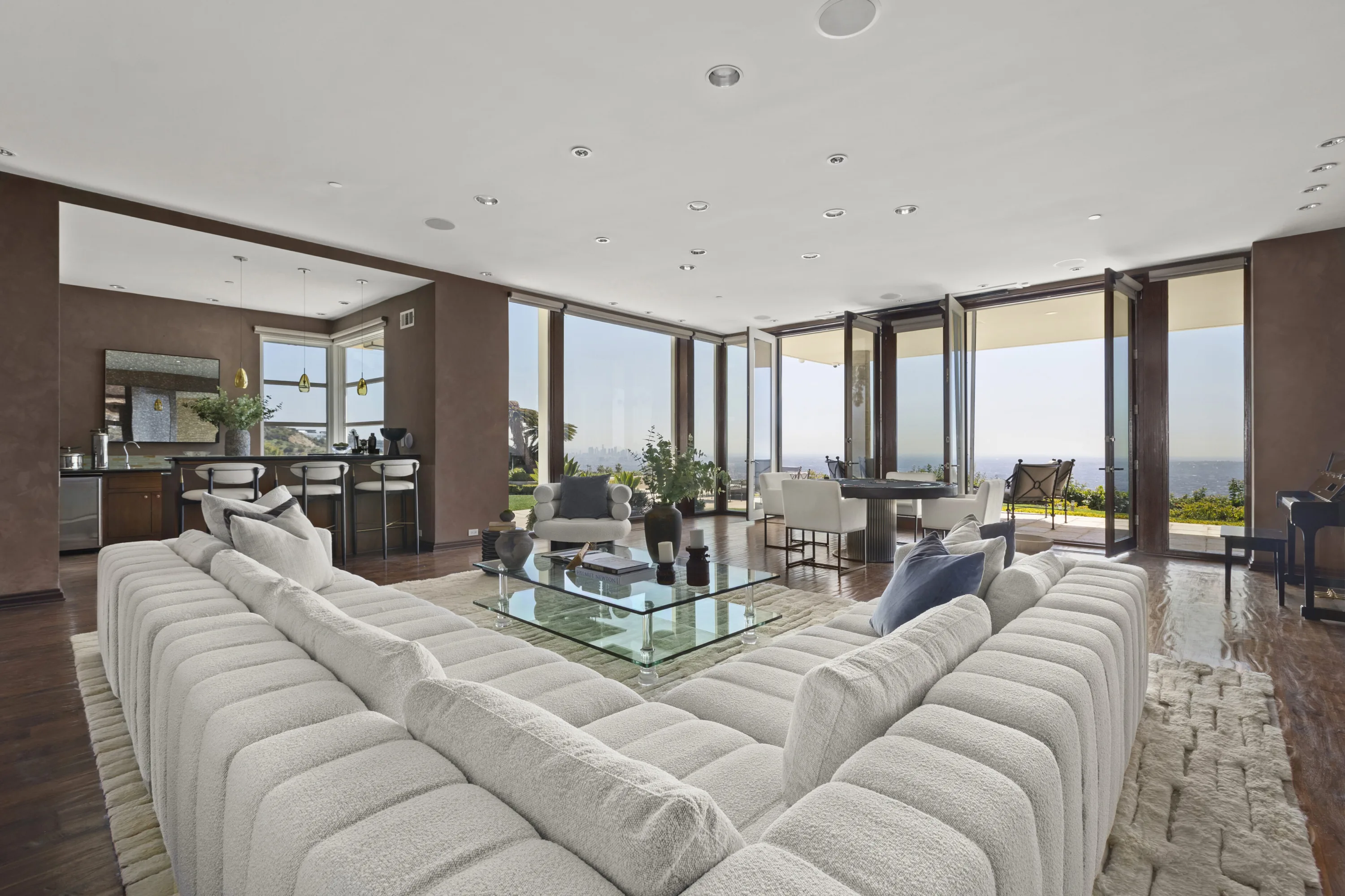 Grand room with oversized boucle sectional, wet bar and glass doors framing the Century City skyline
