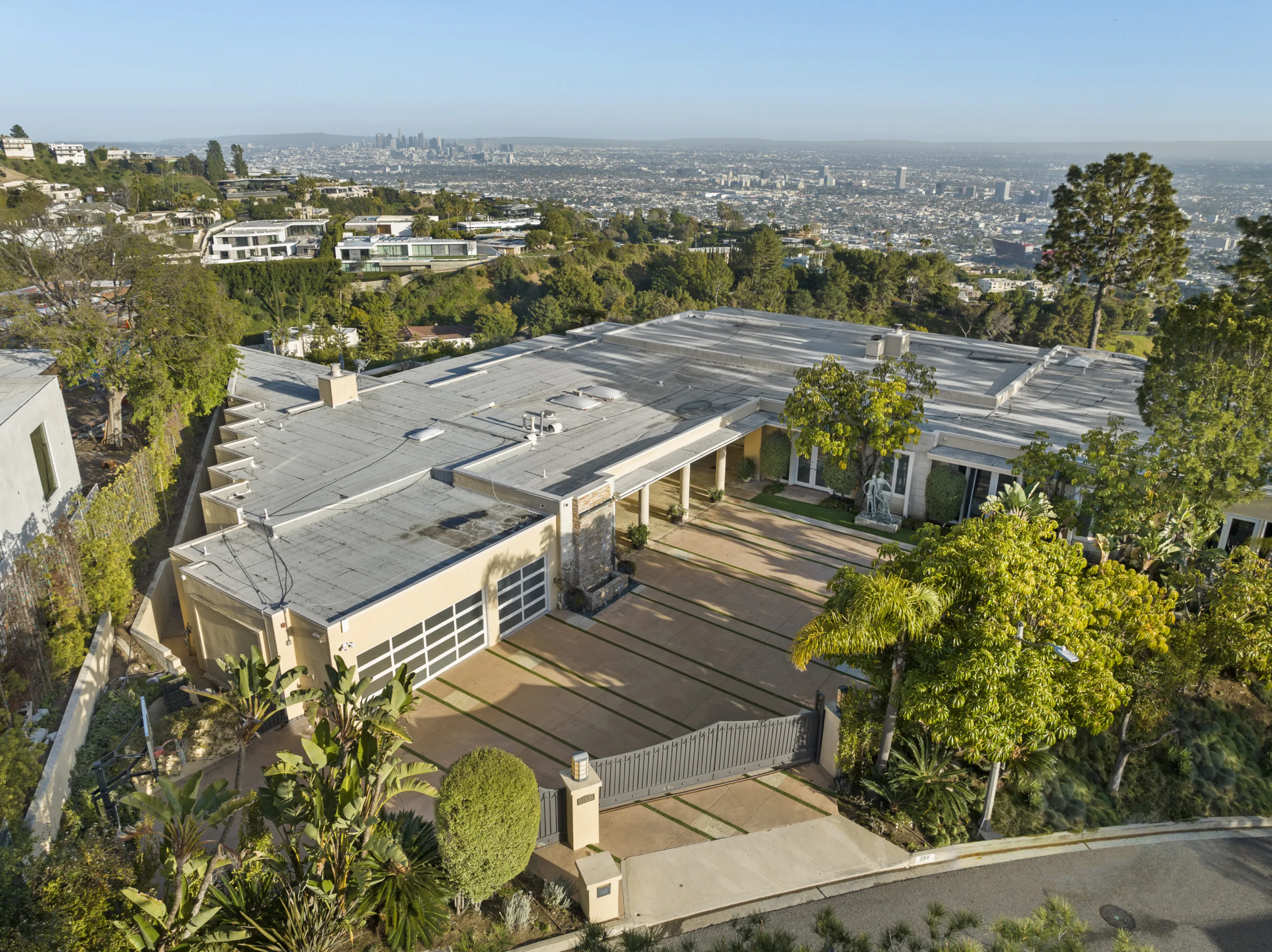 Gated motor court and garages from the air, with downtown Los Angeles on the horizon