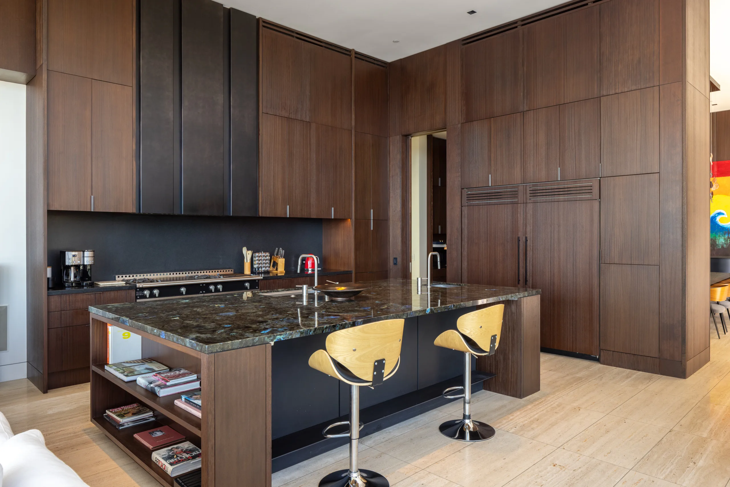 Chef's kitchen with dark walnut cabinetry, stone island and two swivel bar stools