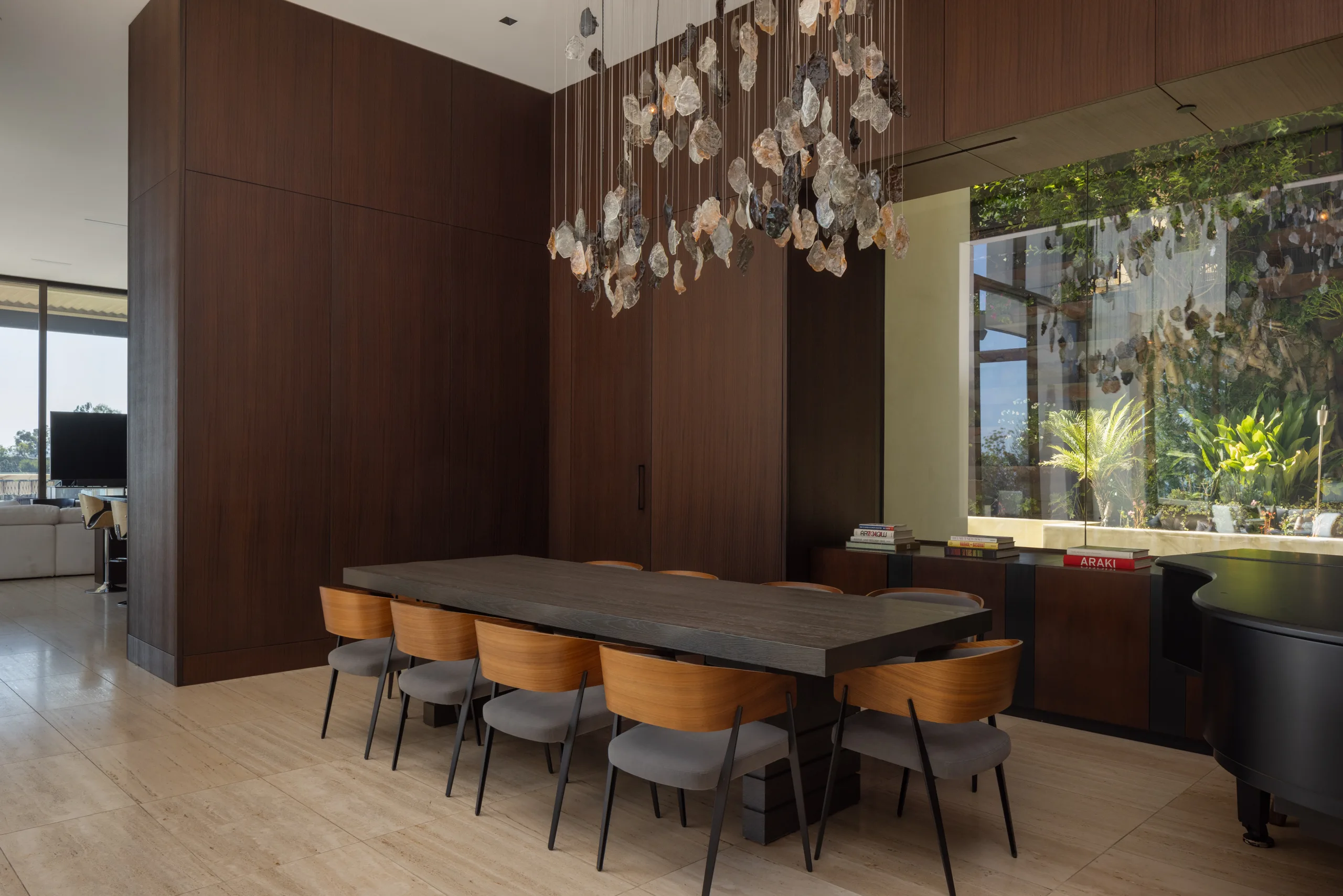 Dining table for ten under a cluster chandelier, garden window and grand piano alongside