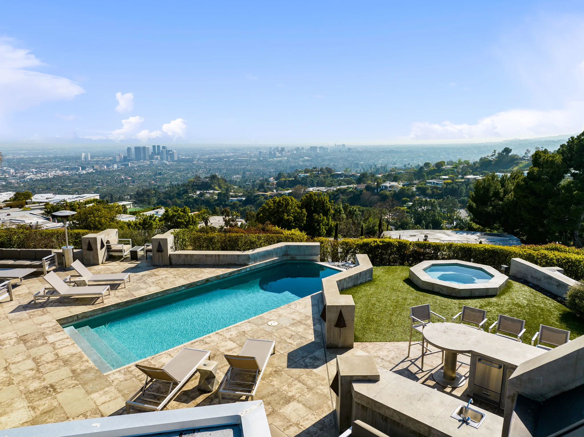 Elevated view across pool, spa and loungers to Century City towers and the basin beyond