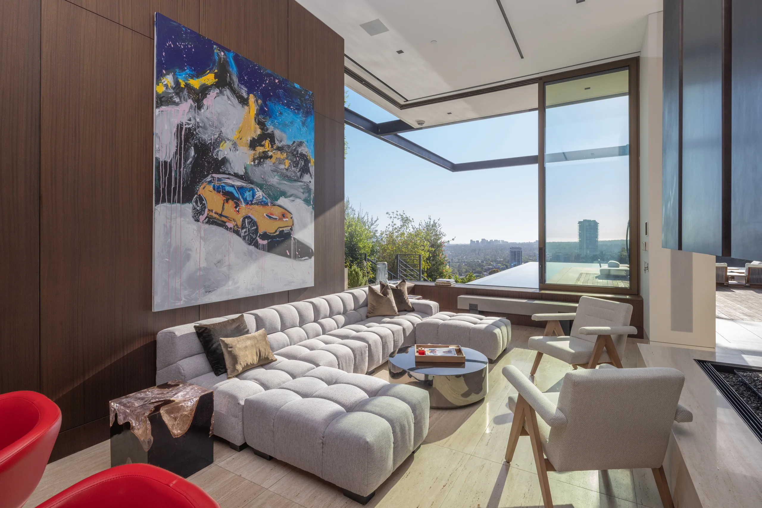 Sitting area with oversized pop-art canvas and glass corner walls opening to the pool and hillside view