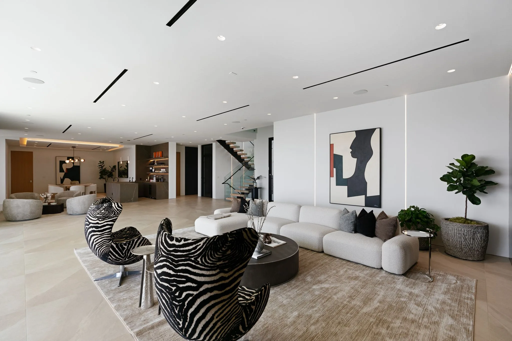 Open-plan lounge running past the floating staircase to the bar and dining area