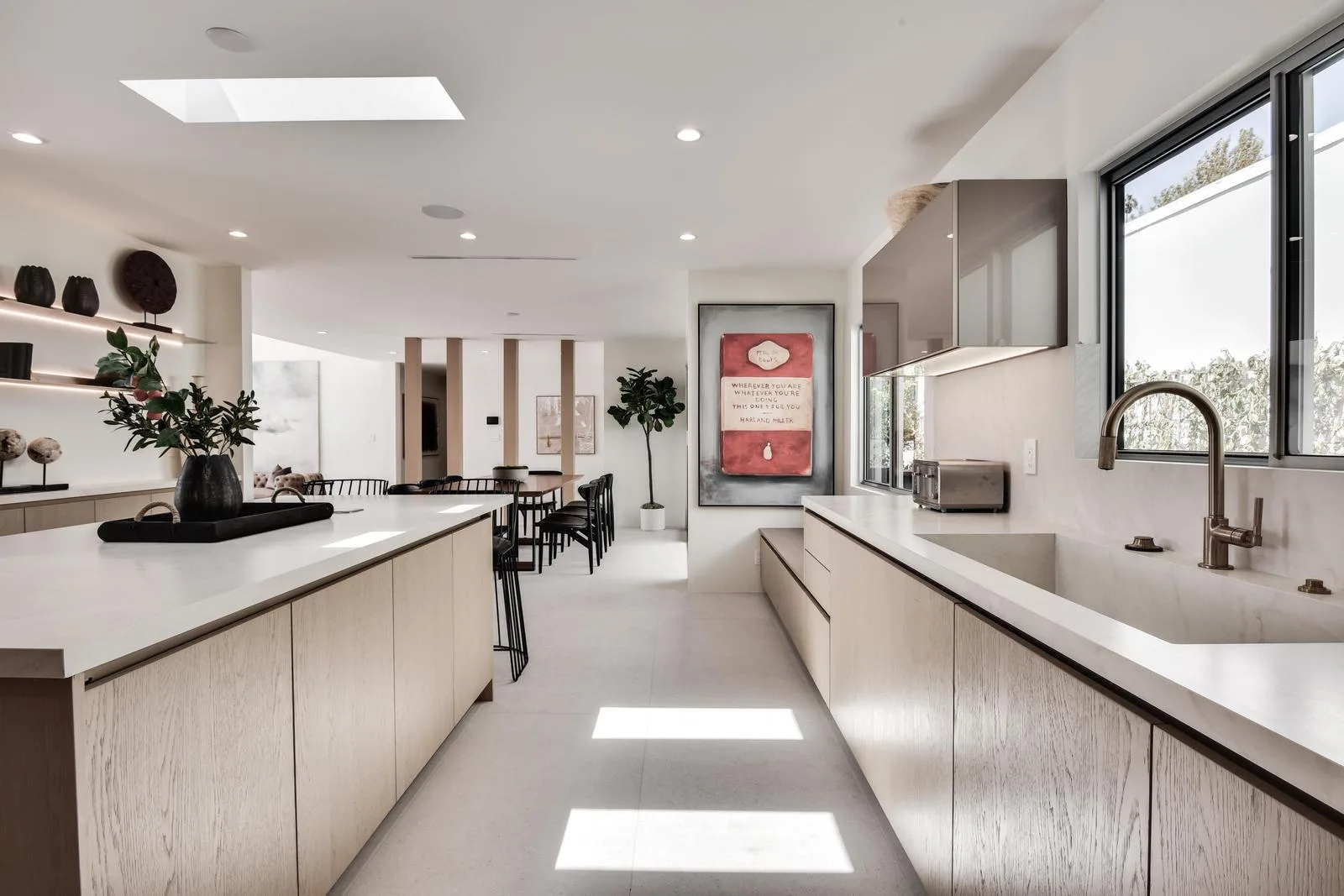 Chef's kitchen with skylit island, quartz counters and a farmhouse sink facing the breakfast table