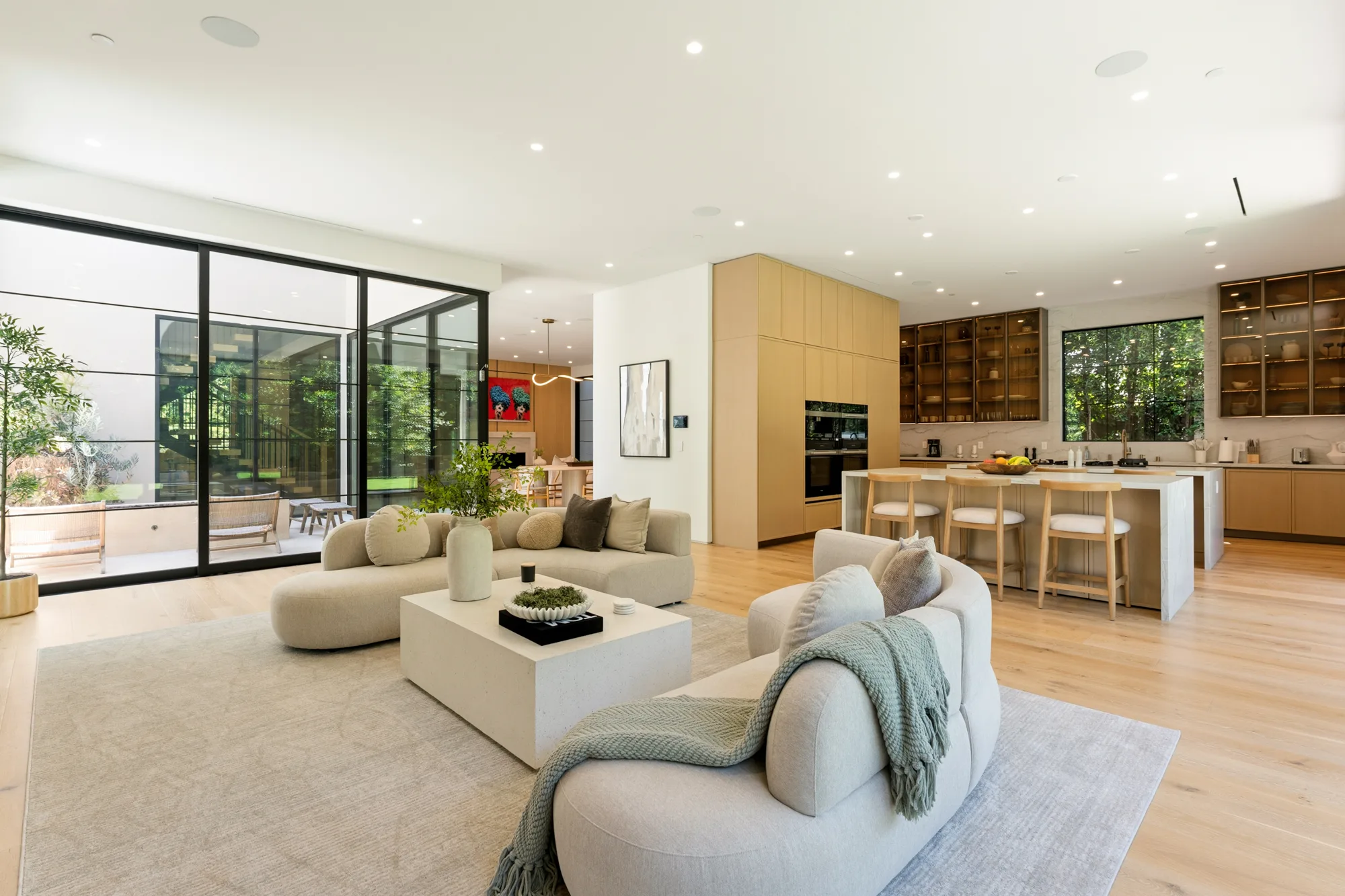 Great room looking through to the chef's kitchen island and barstools, terrace doors to the left
