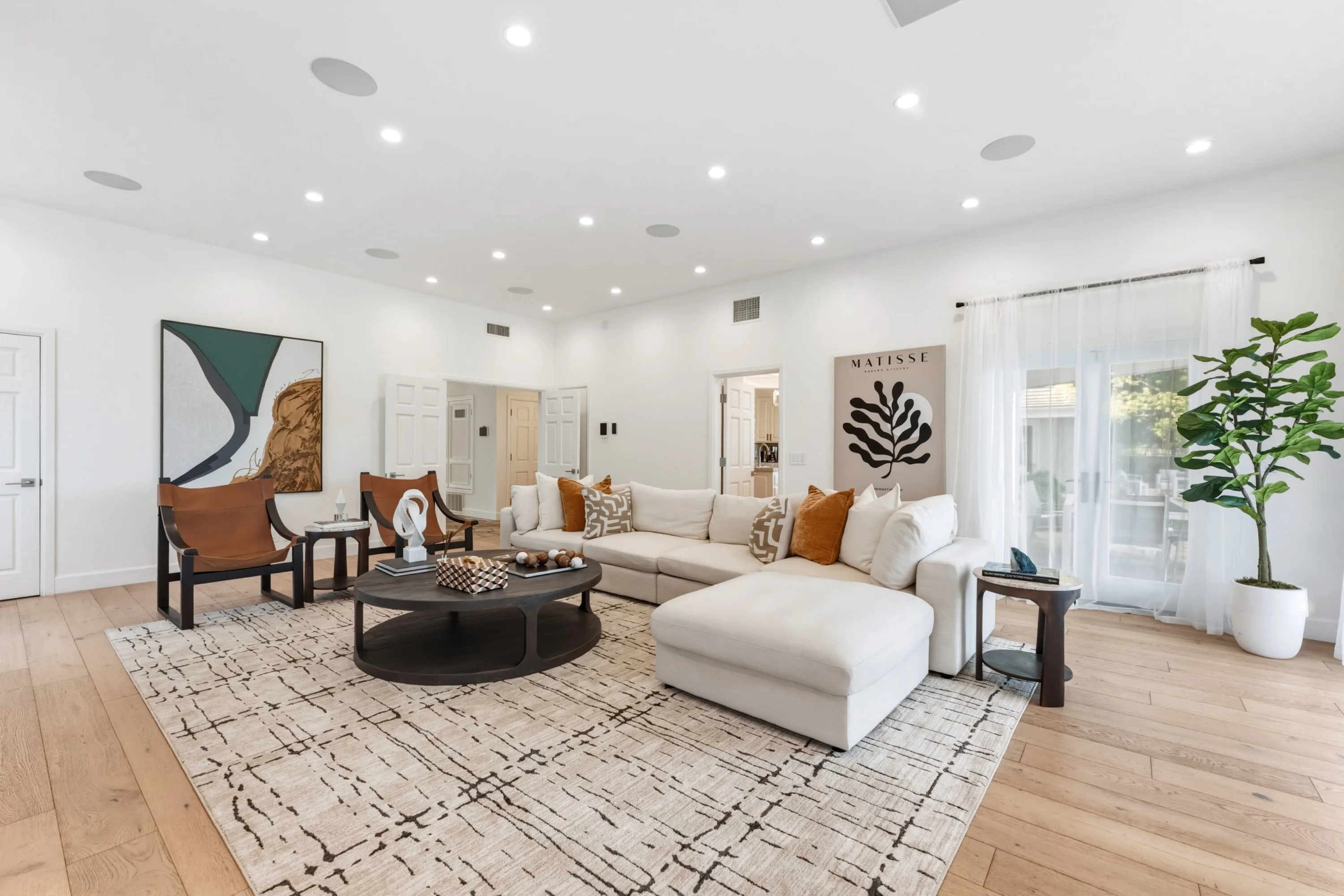 Second lounge with ivory sectional, leather sling chairs and sliding doors to the side terrace