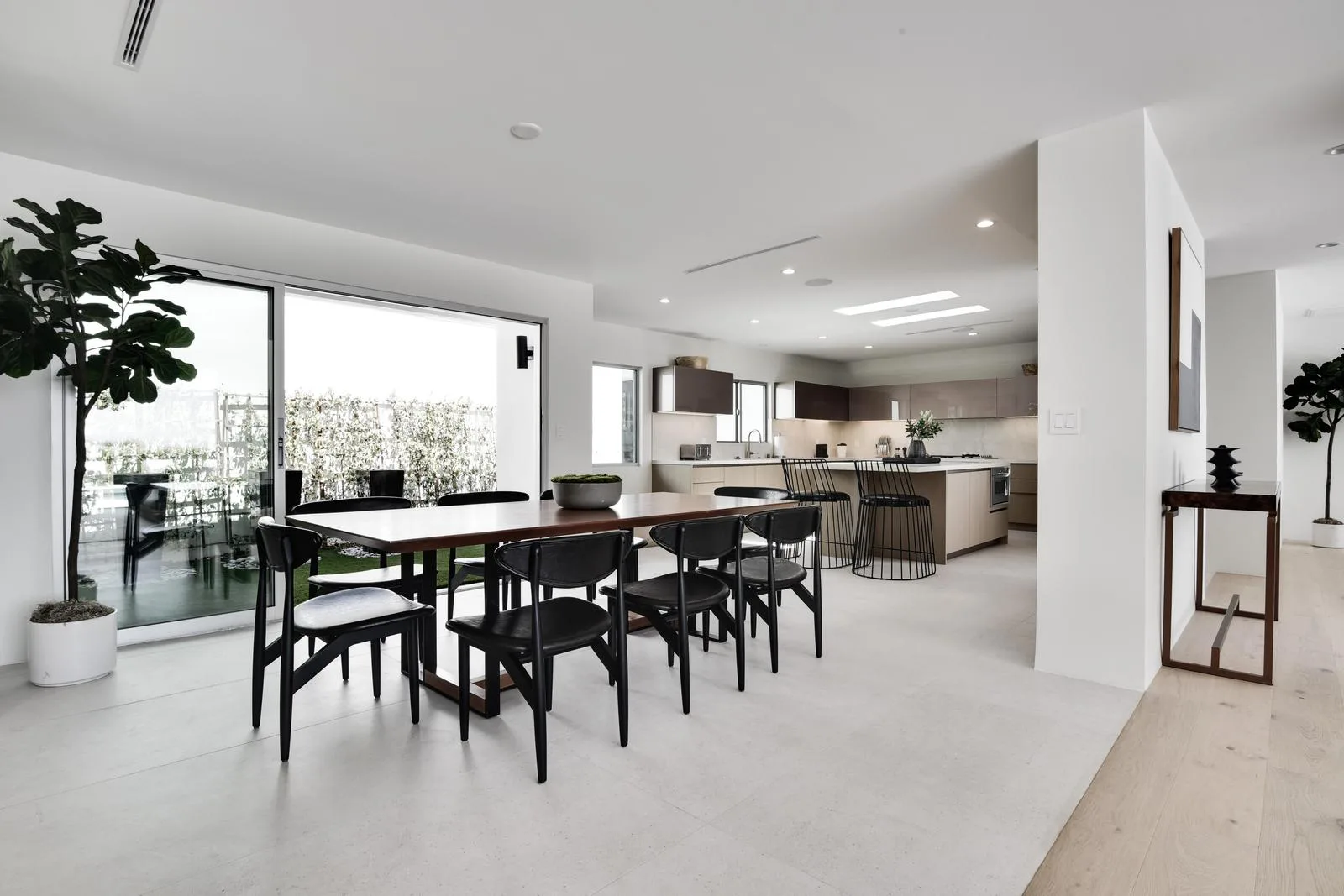 Dining table beside sliding doors to the lawn, with the kitchen and breakfast bar just steps away