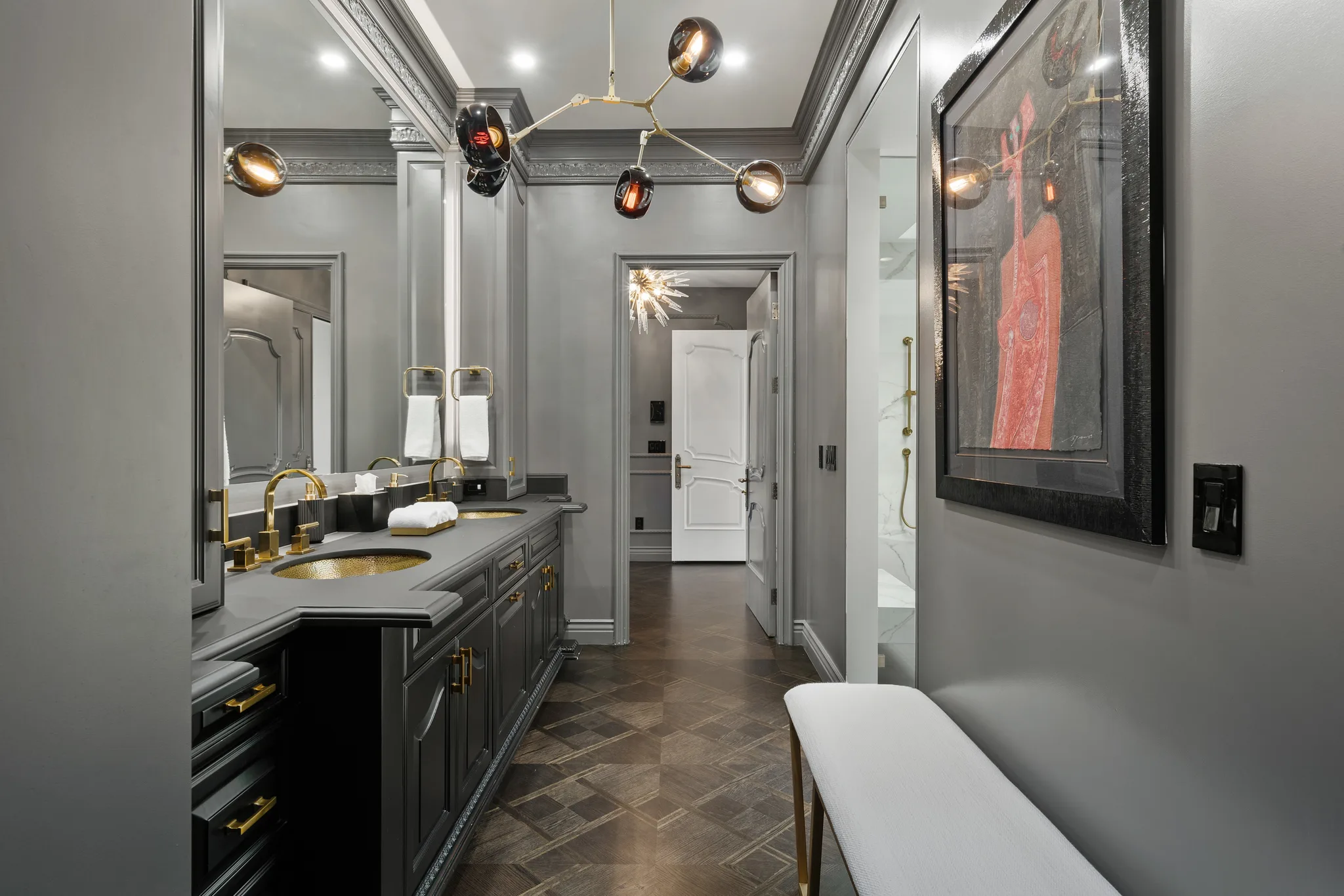 Long grey marble bathroom corridor with twin sinks, herringbone floor and walk-in shower