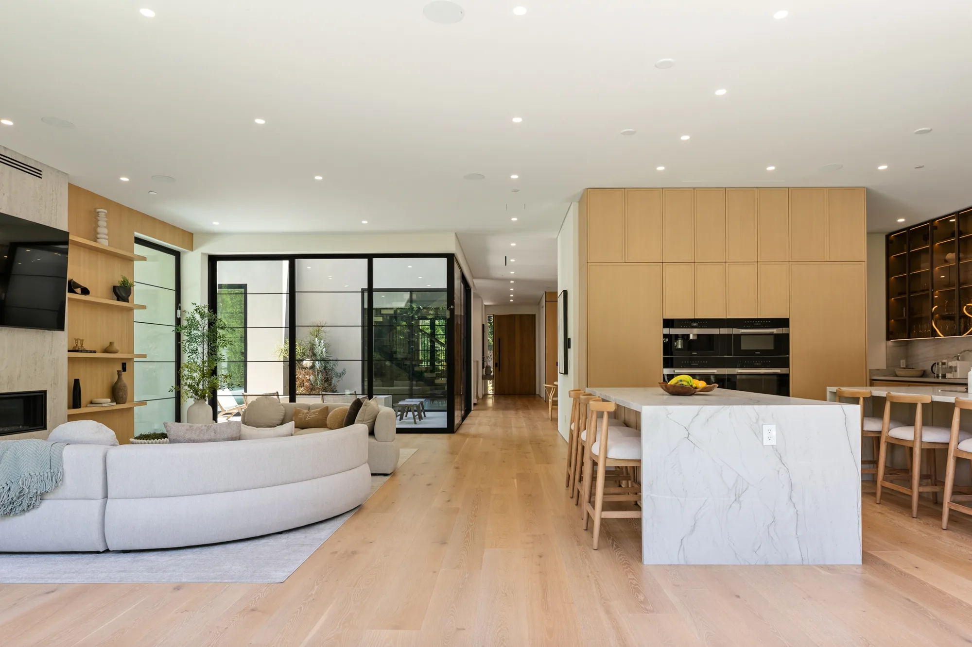 Long view across the living room, hallway and kitchen island showing the home's open plan