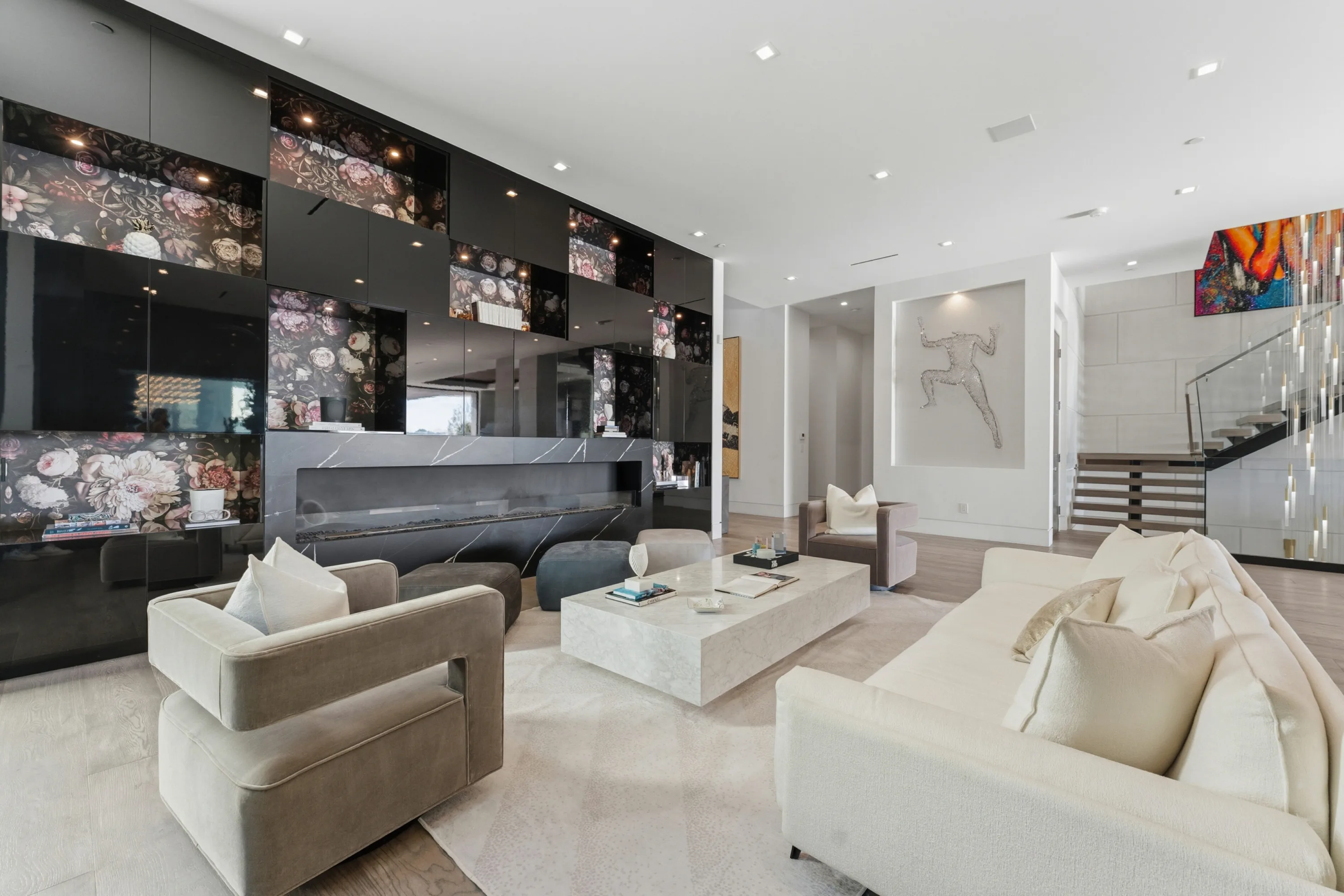 Formal lounge with long black marble fireplace, floral lacquer panelling and cream seating around a stone coffee table