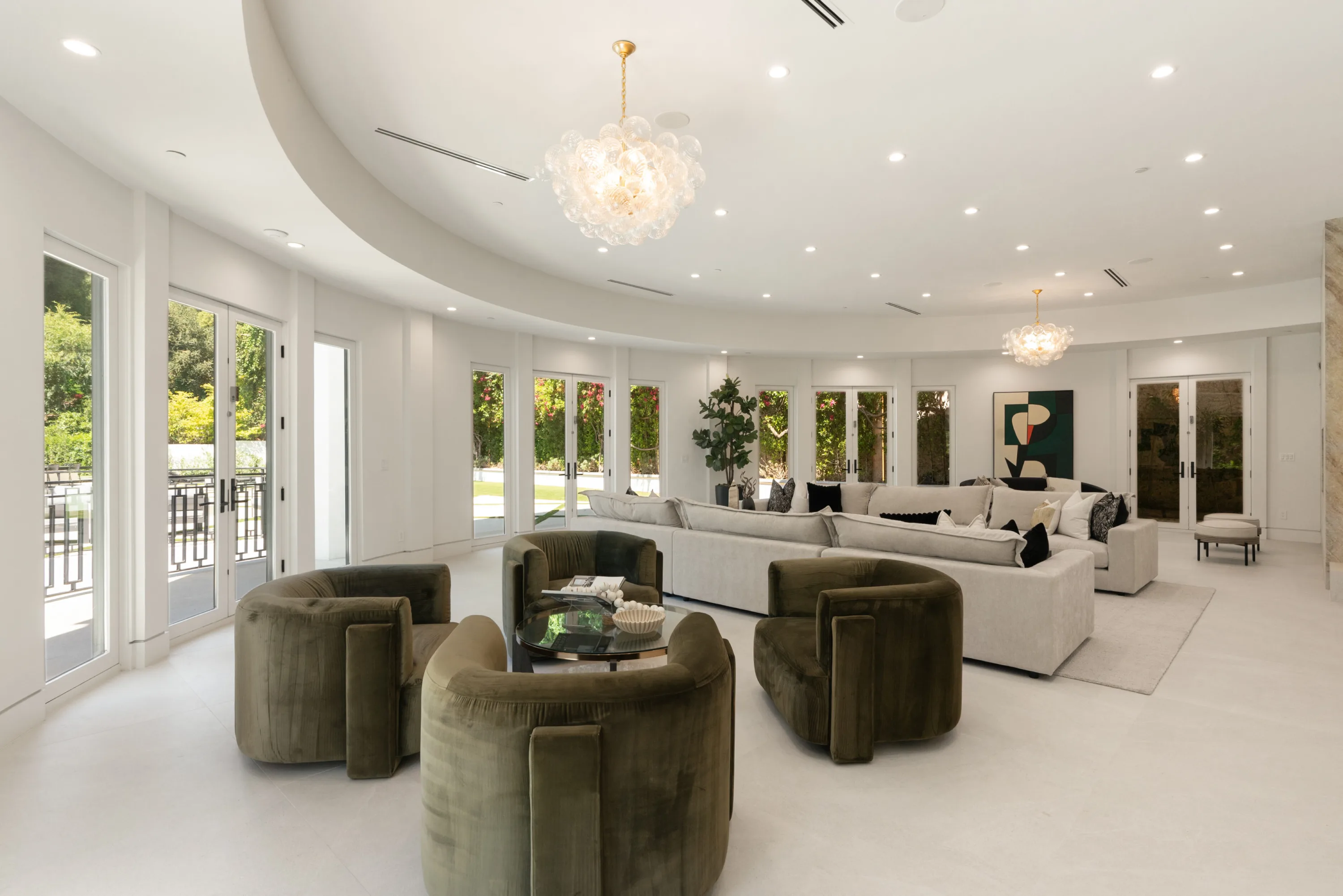 Second angle of the great room showing olive velvet swivel chairs and a deep sectional under domed ceiling