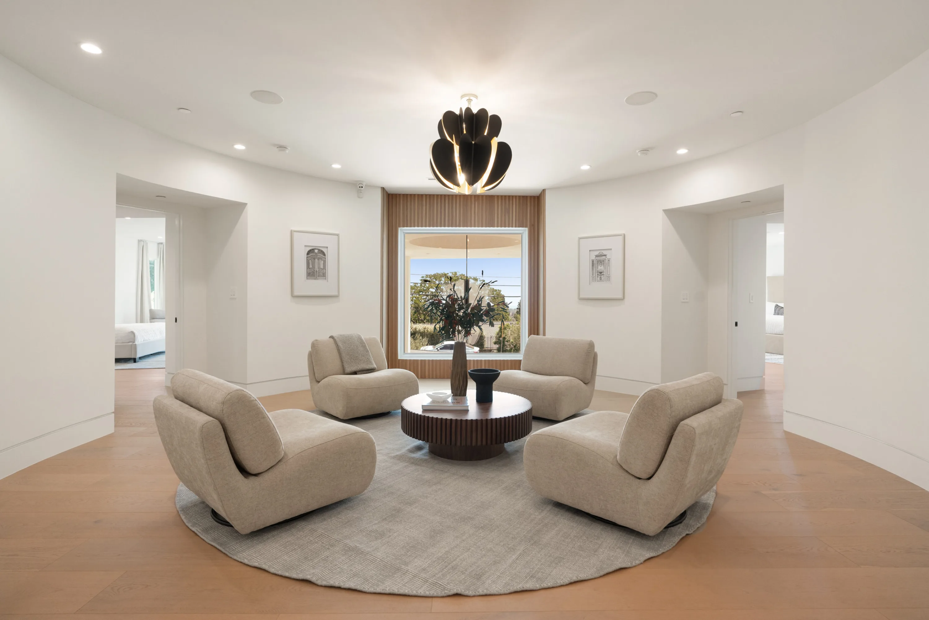 Upstairs lounge with four swivel chairs circled around a fluted table under a sculptural black pendant