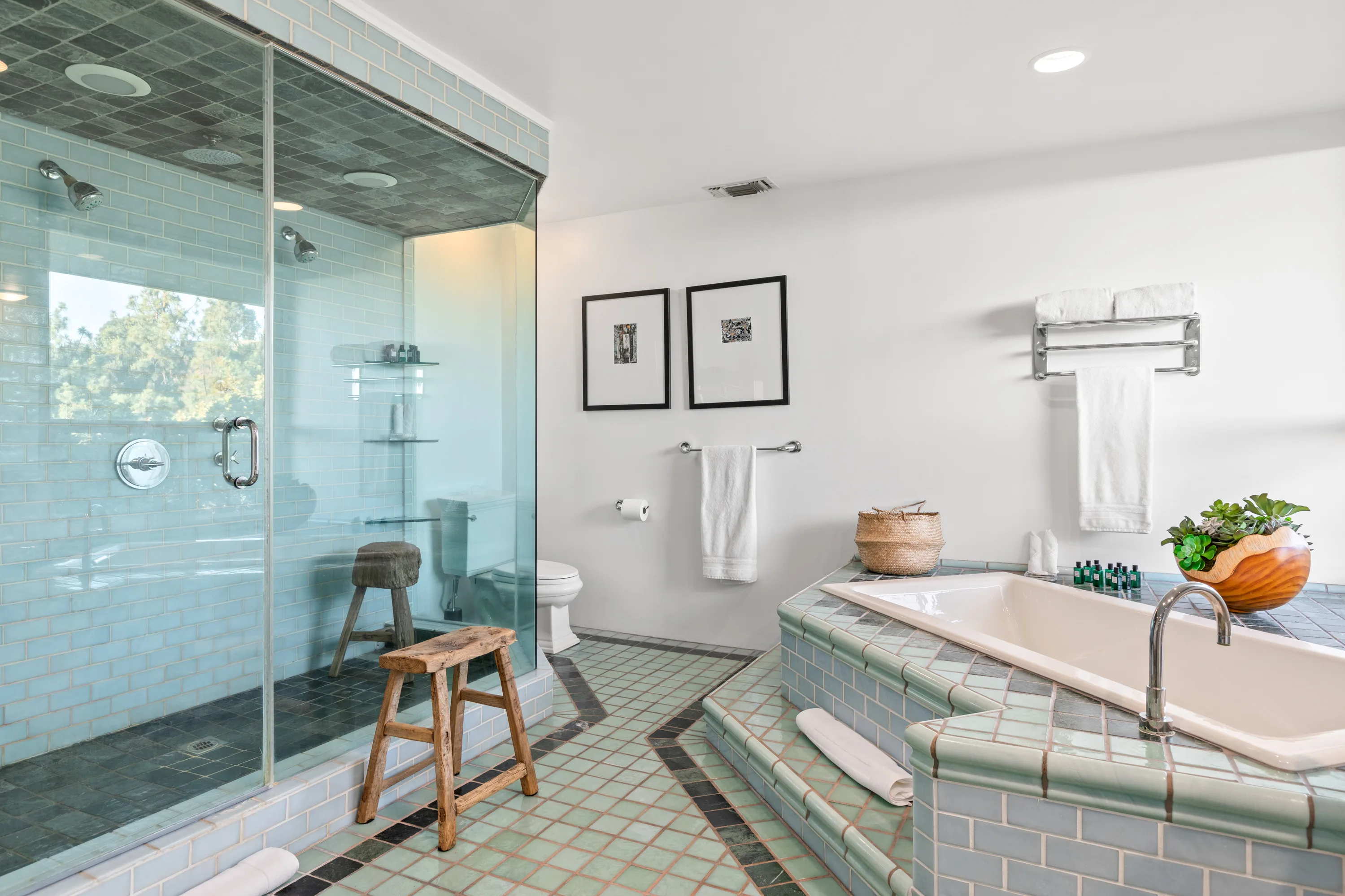 Wide walk-in glass steam shower and tiled soaking tub in the retro-tiled primary bathroom