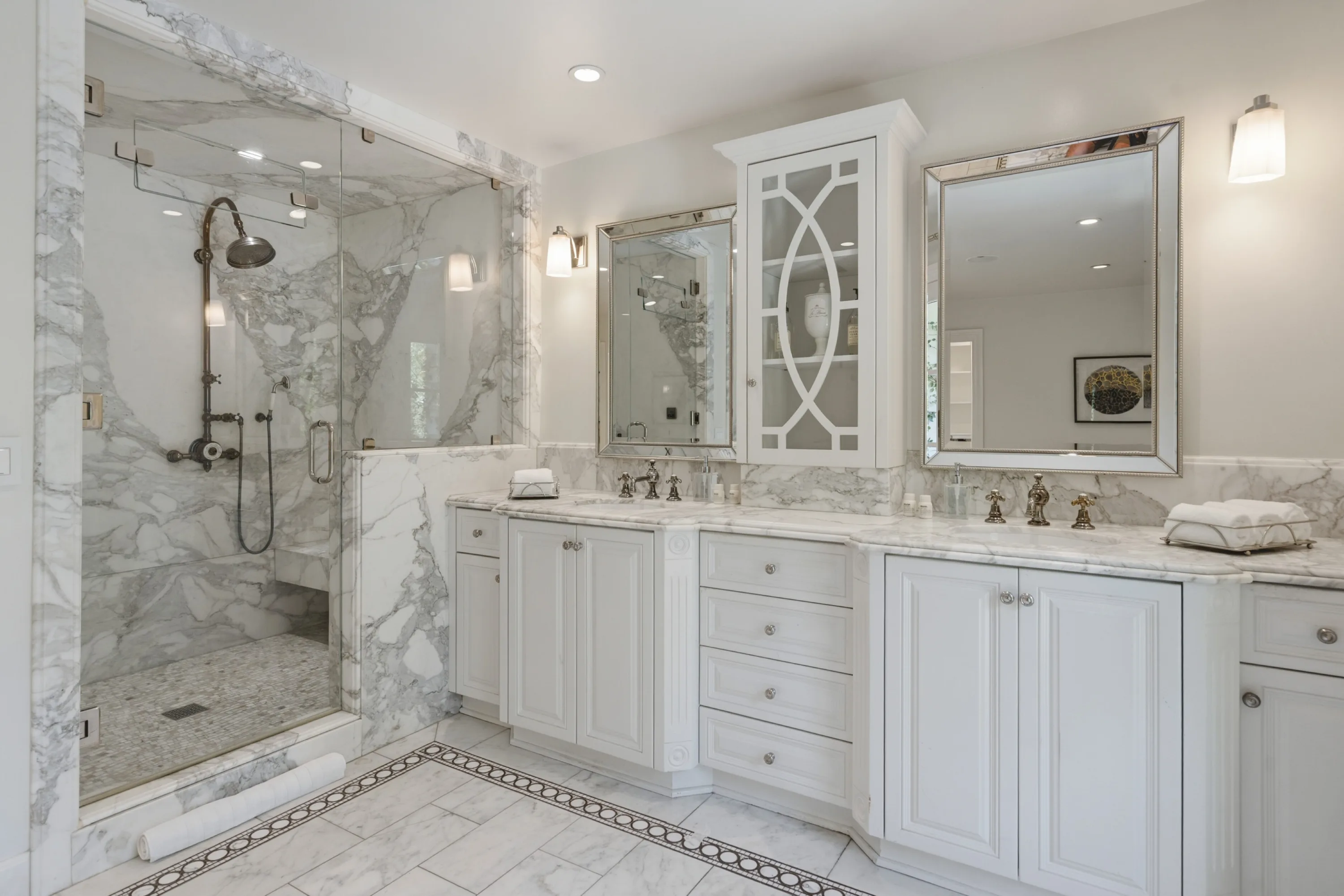 His-and-hers vanity wall and walk-in marble steam shower in the primary bathroom