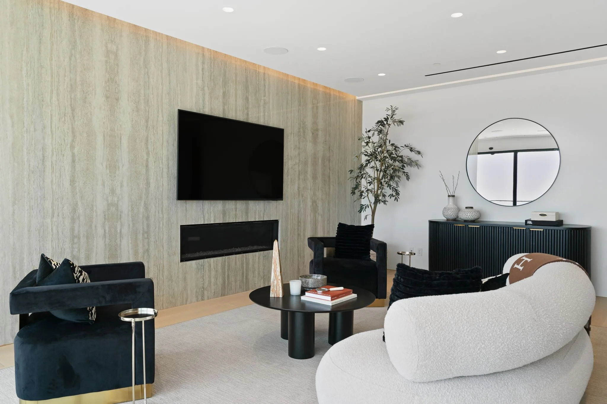Sitting area in the suite with linear fireplace and TV set into a travertine wall