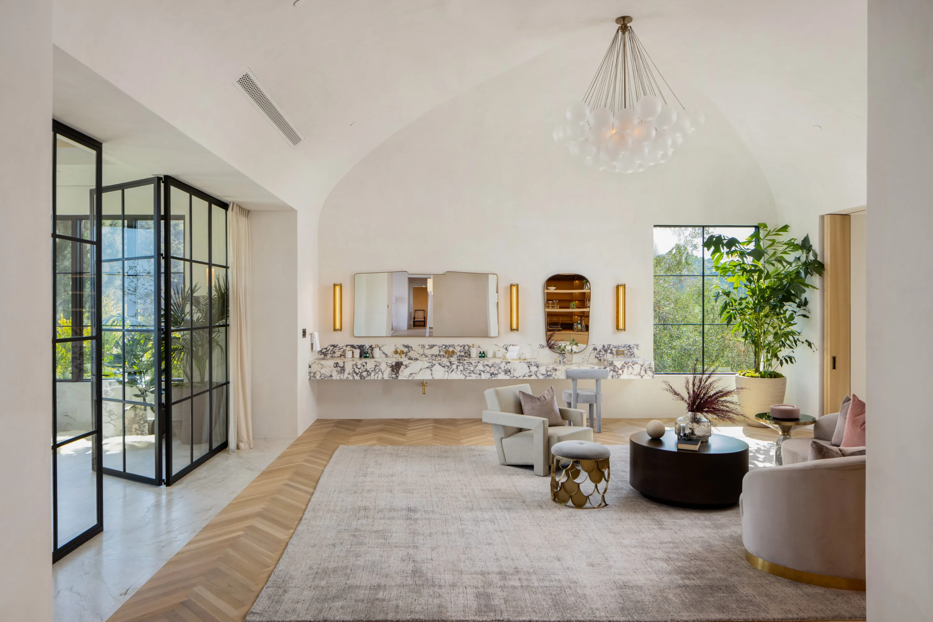 Vaulted sitting room with bubble chandelier, veined marble vanity ledge and steel garden doors