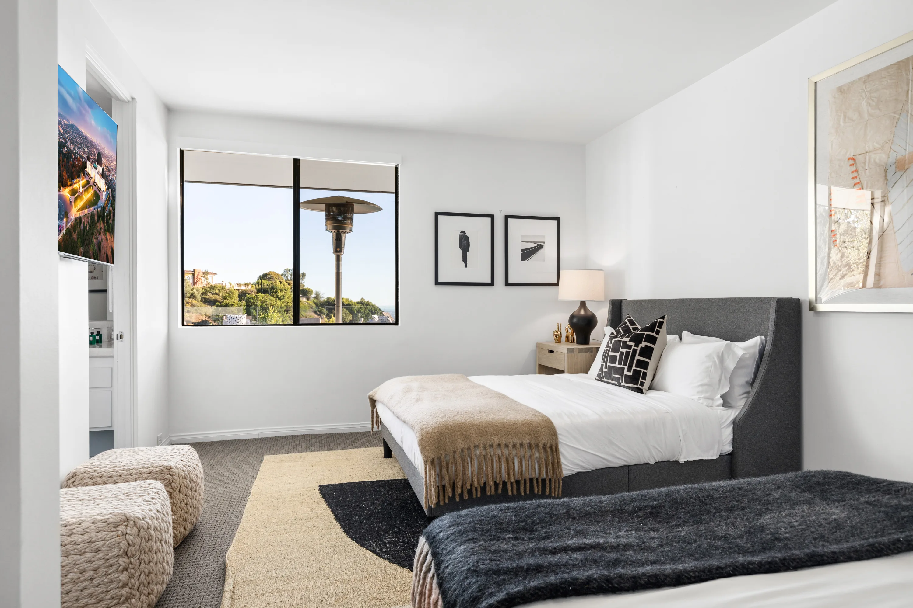 Twin-bed guest room with hillside outlook through the corner window and black-and-white prints