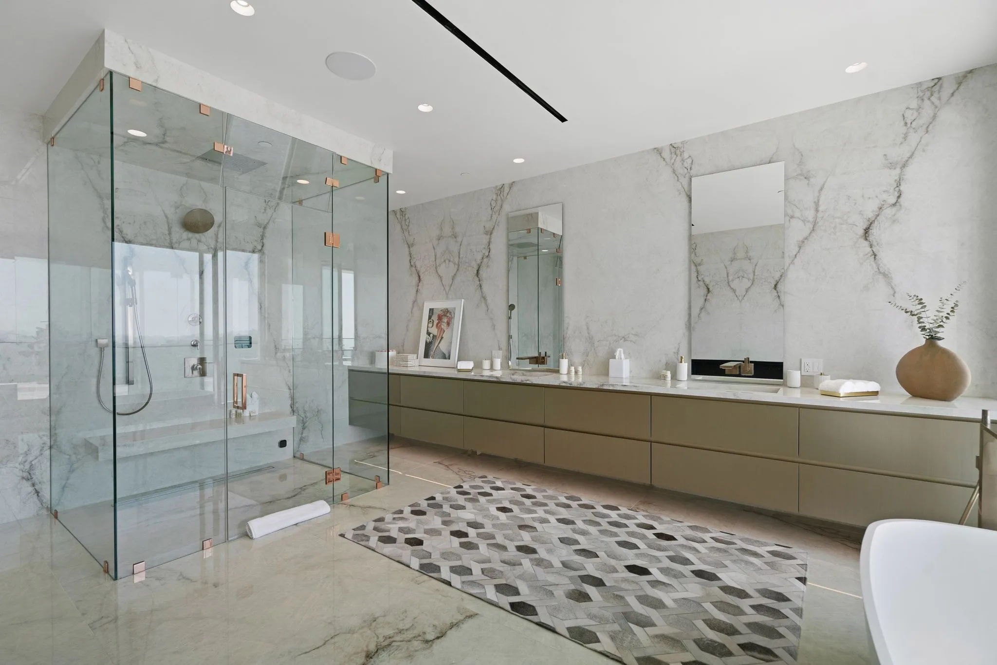 Book-matched marble bathroom with walk-in glass steam shower and twin mirrors over the vanity