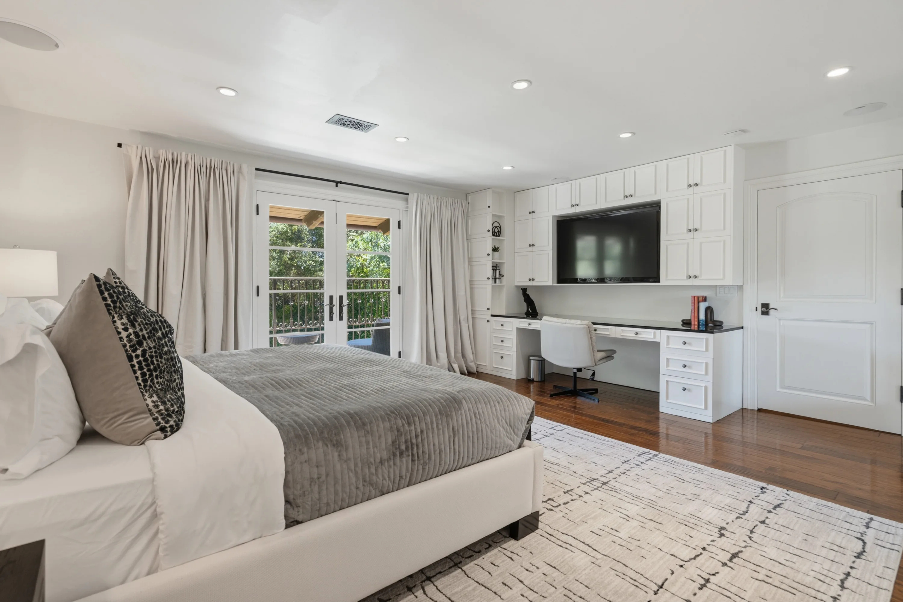 Second view of the same guest room, with built-in desk, cabinetry and wall-mounted TV