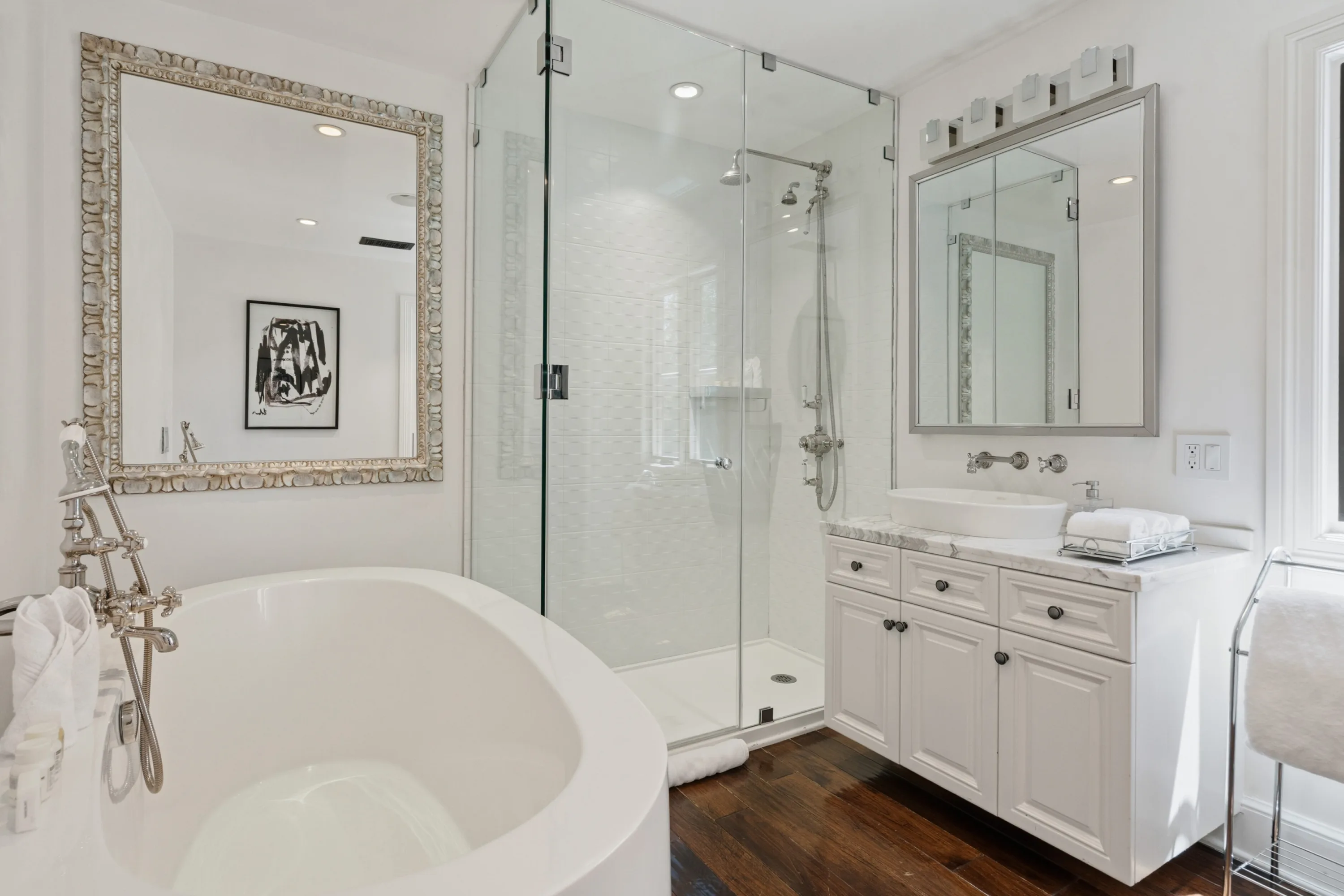 Guest bathroom with freestanding oval tub, glass walk-in shower and vessel sink on marble