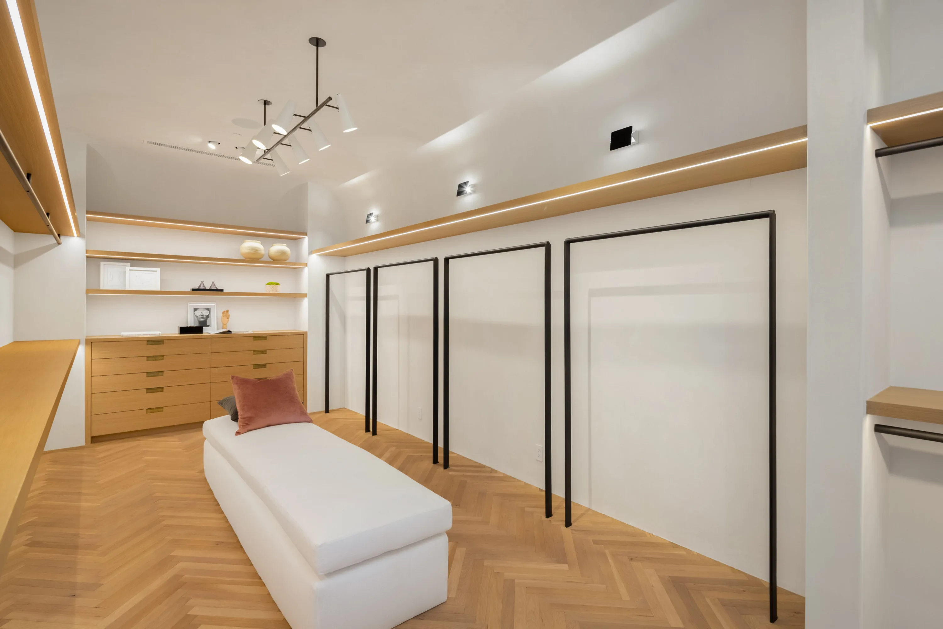 Walk-in dressing room with oak drawer bank, herringbone floor and upholstered bench