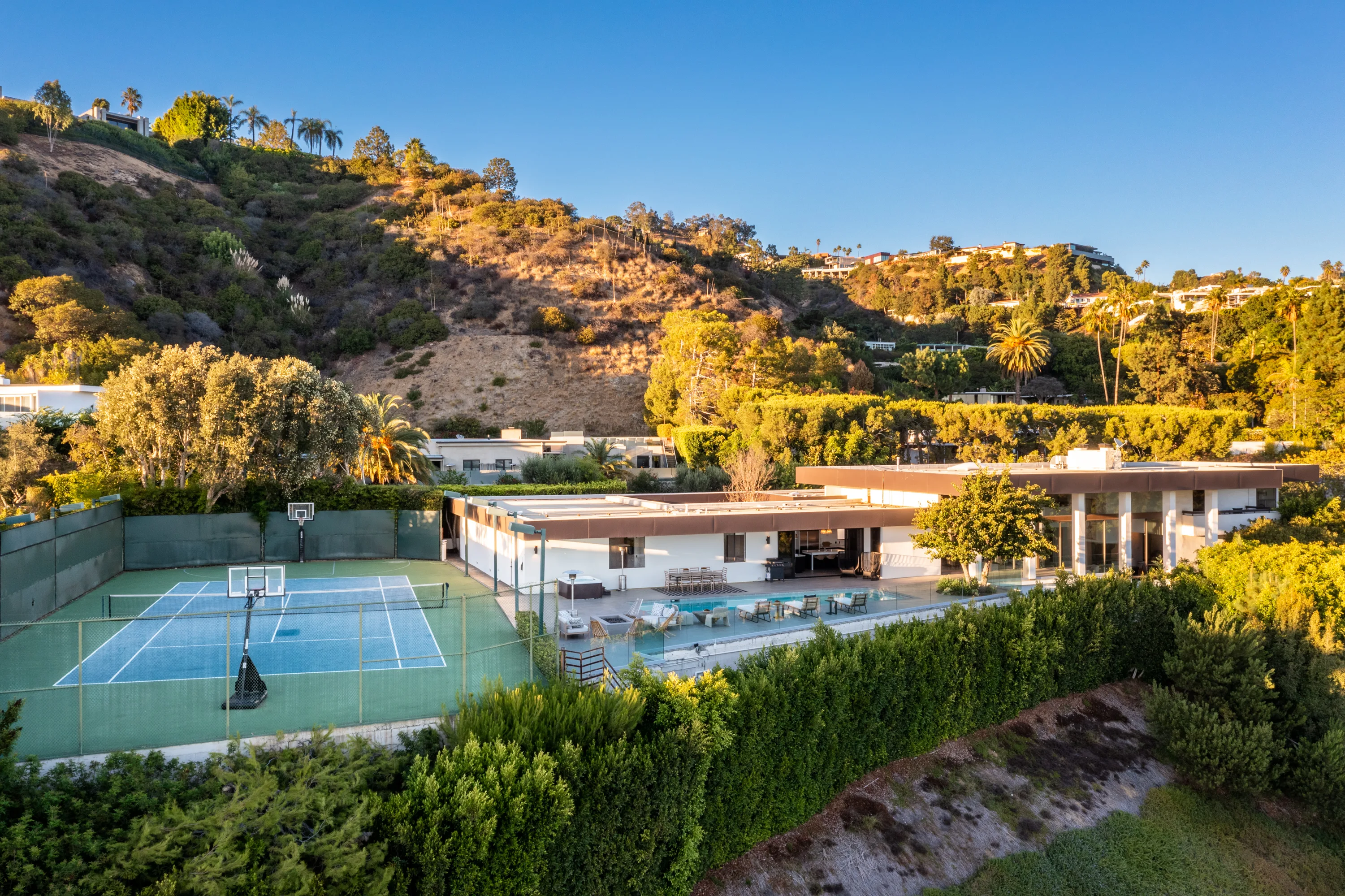 Aerial over the Trousdale estate showing tennis court, pool terrace and hillside homes beyond