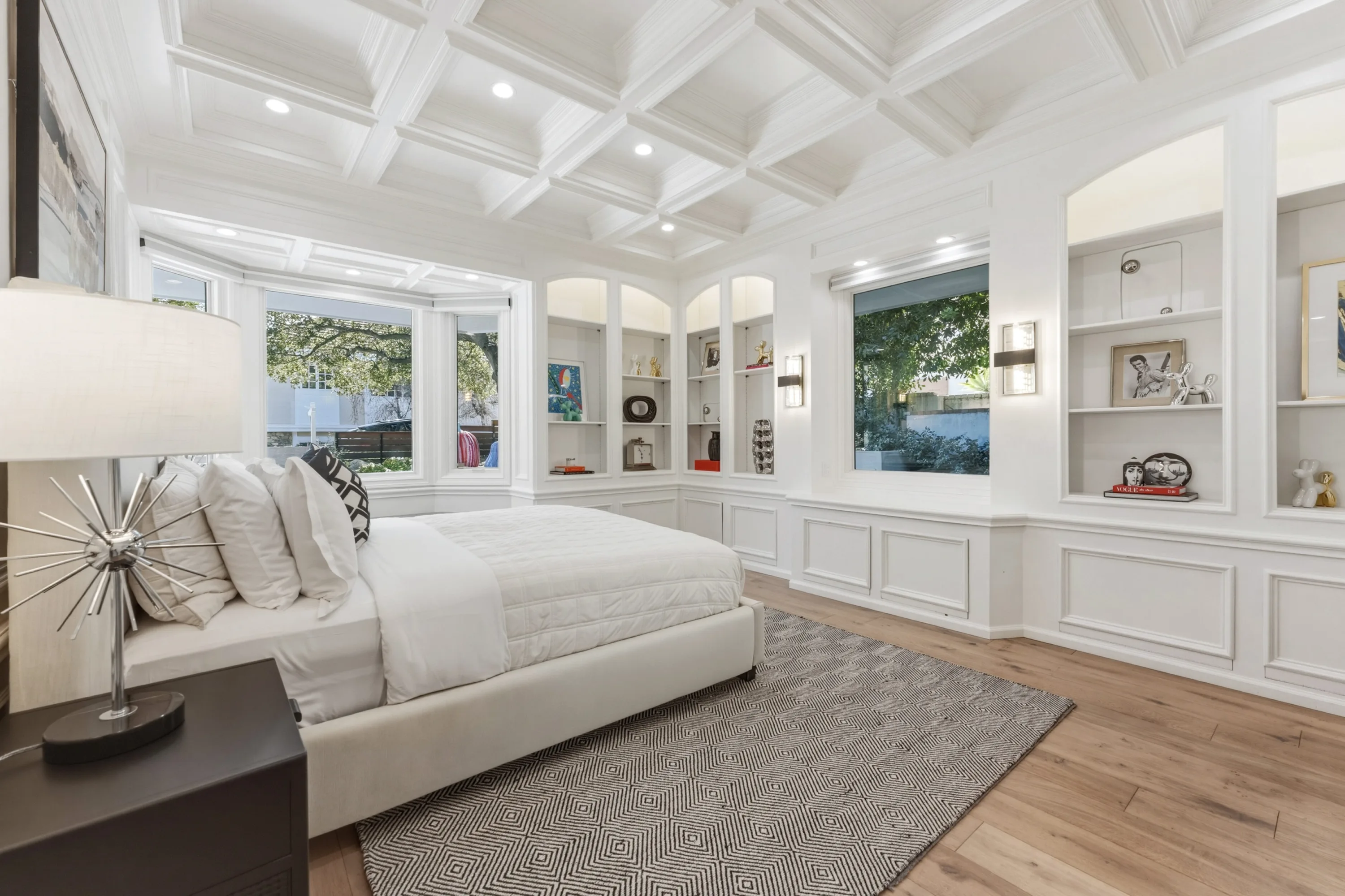 Primary suite with coffered ceiling, bay window seat and arched built-in shelving