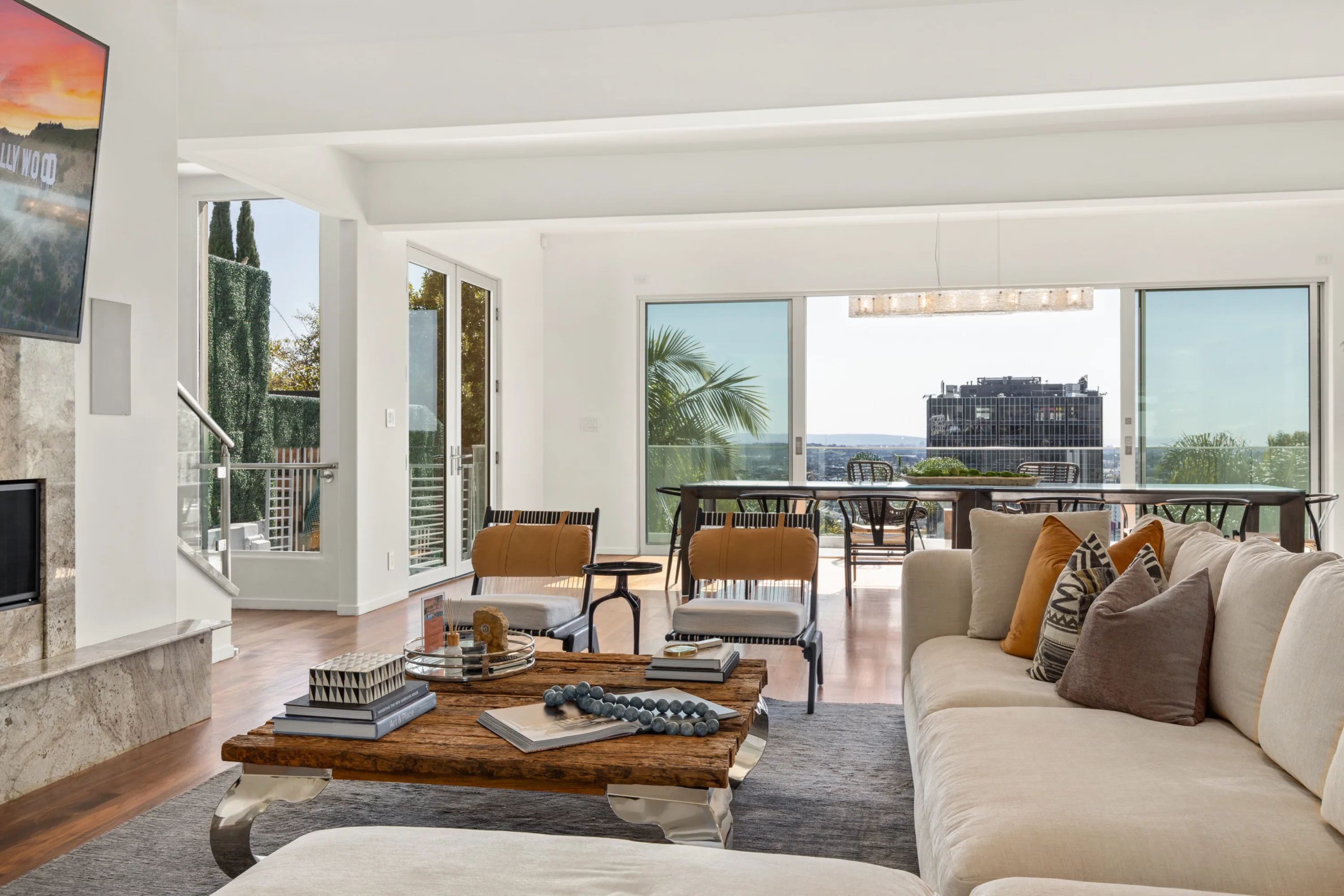 Sitting area looking through sliding glass walls to the dining table and high-rise skyline view