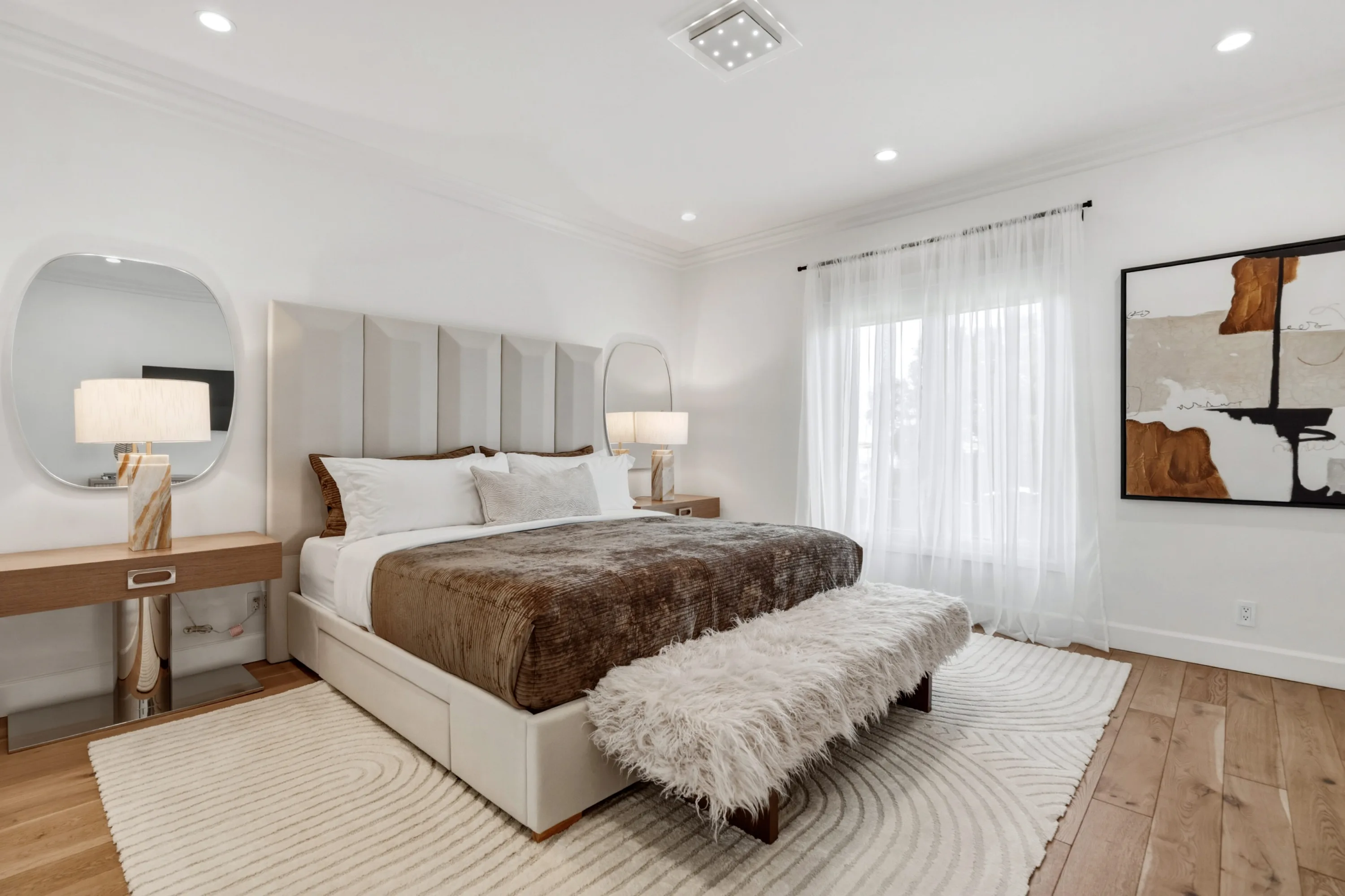 Airy bedroom with channel-tufted headboard, velvet throw and shaggy bench at the foot of the bed