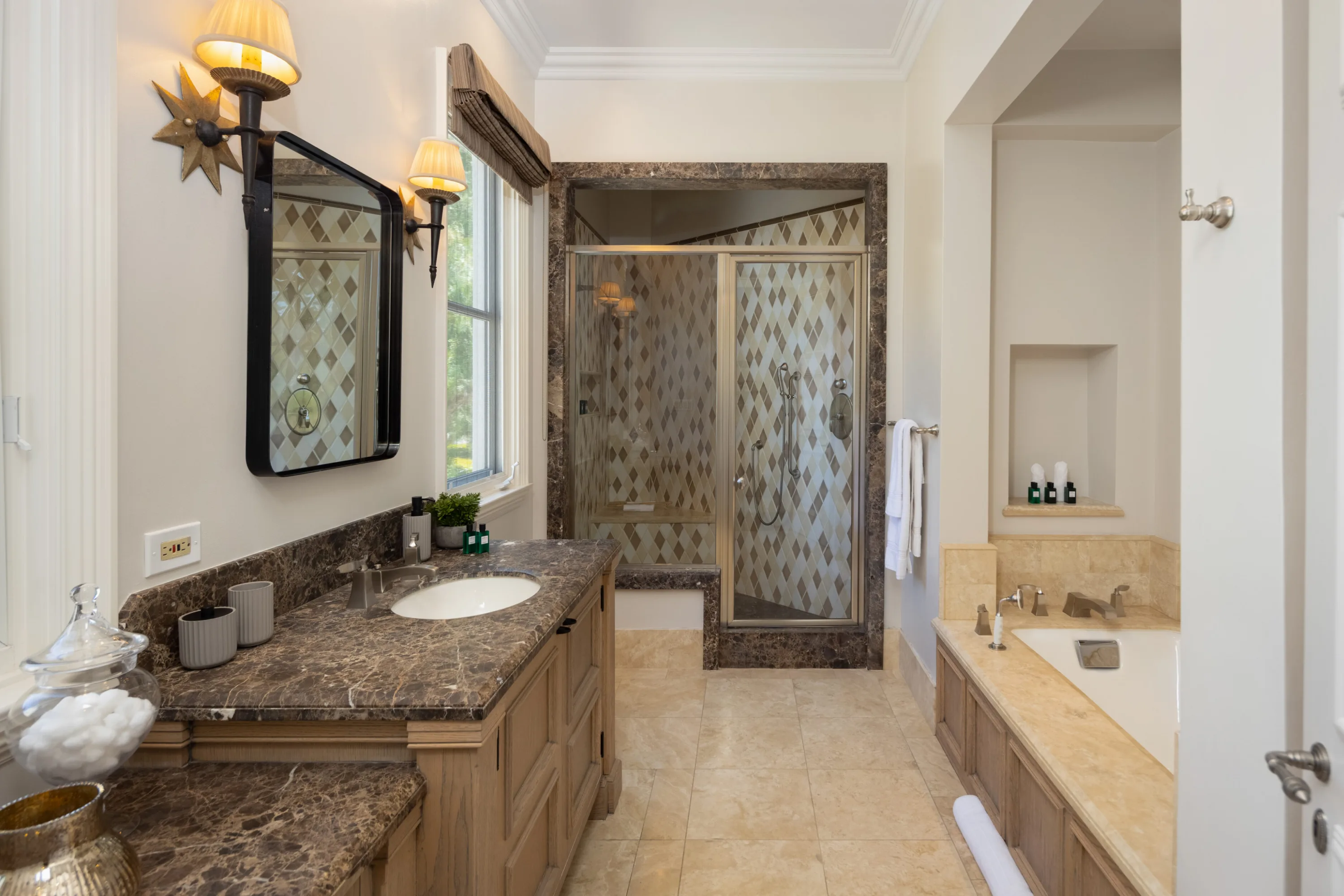 Traditional guest bath with marble vanity, glass shower and drop-in tub by the window