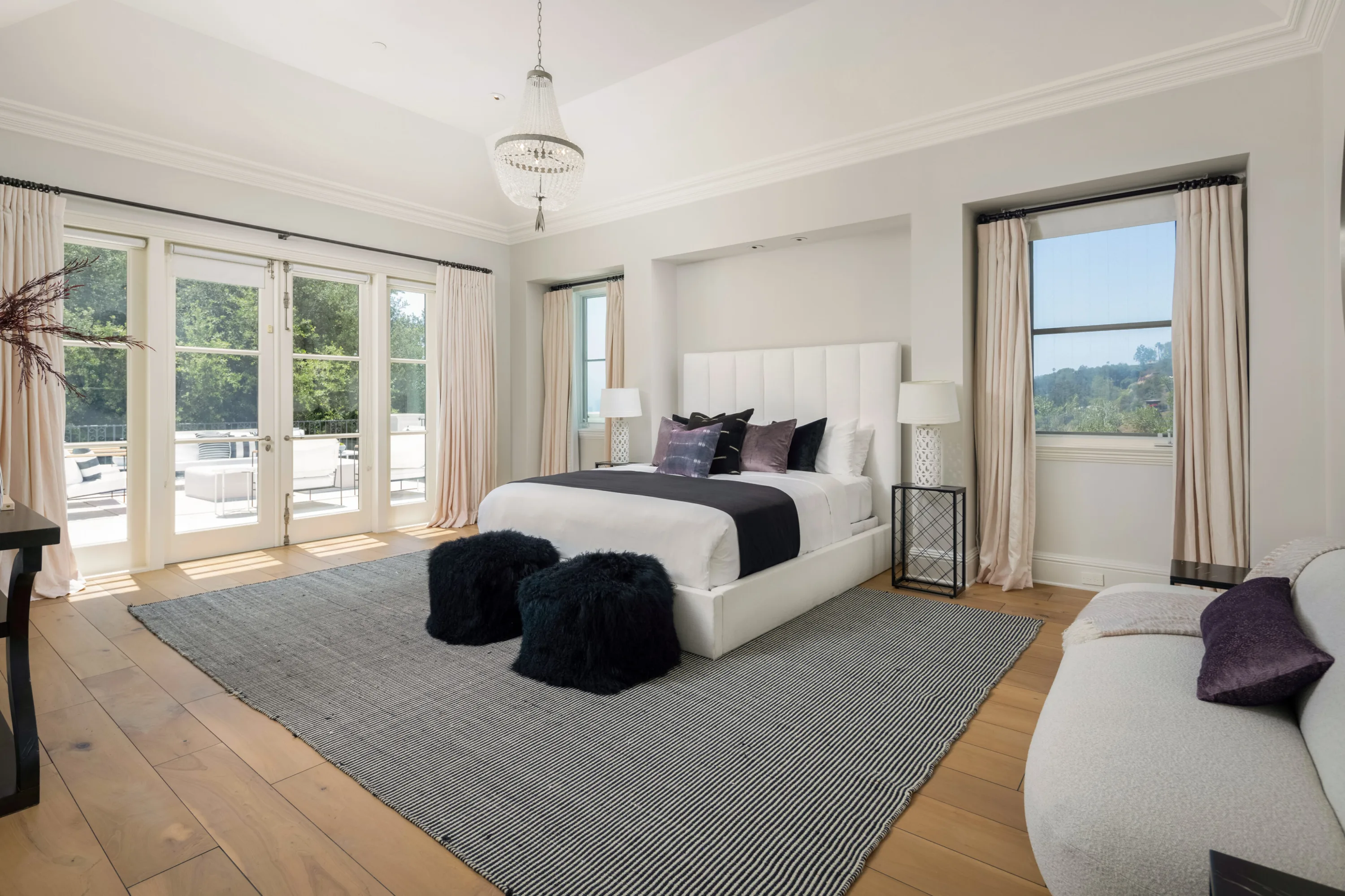 Bright bedroom with beaded chandelier and french doors to a terrace above the canyon