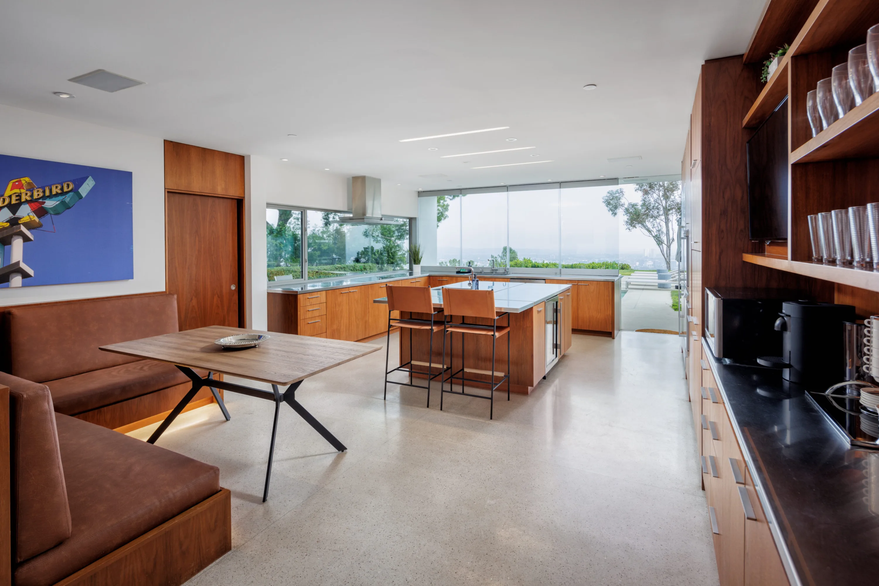 Breakfast banquette and walnut coffee bar looking through to the island kitchen and view windows