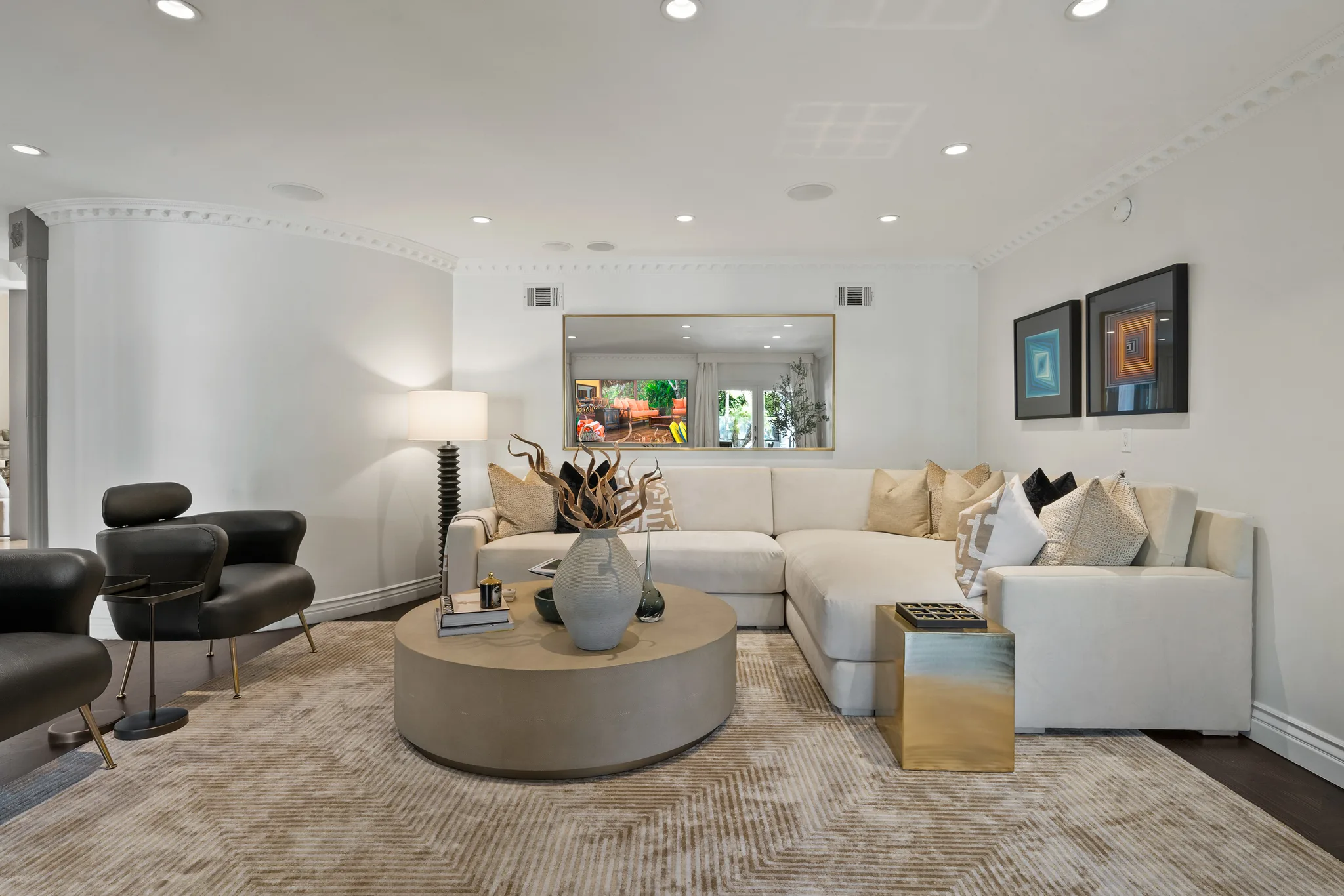 Family den with deep L-shaped sectional, round coffee table and leather swivel chairs