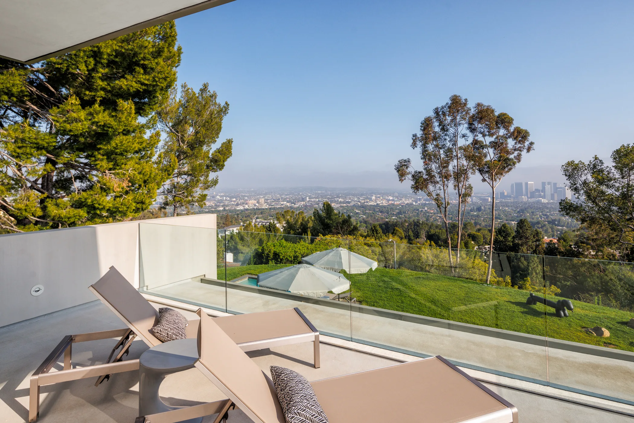 Sun loungers on the upper balcony above the lawn, city stretching to the Century City towers