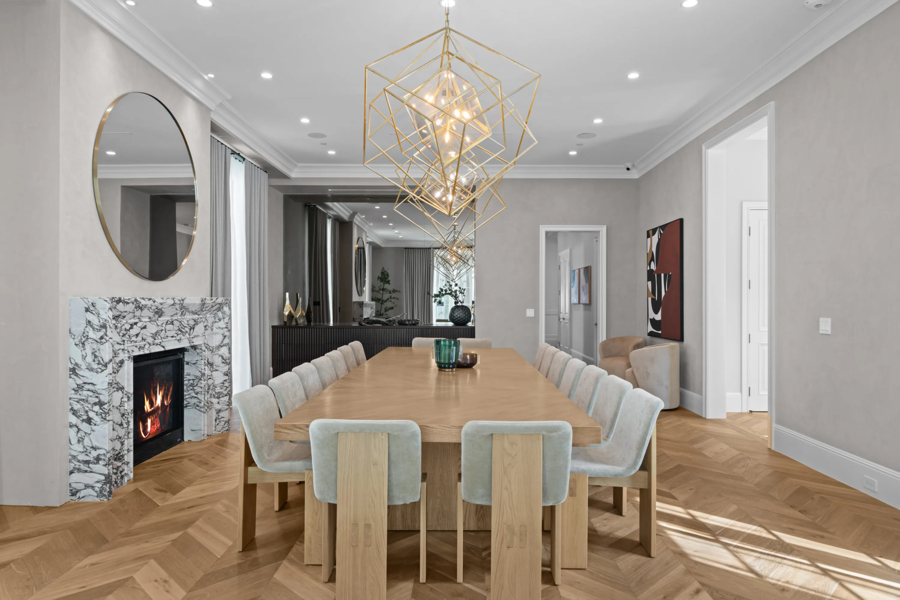 Dining room looking through to the bar area, fire burning in the marble surround beside velvet-backed chairs