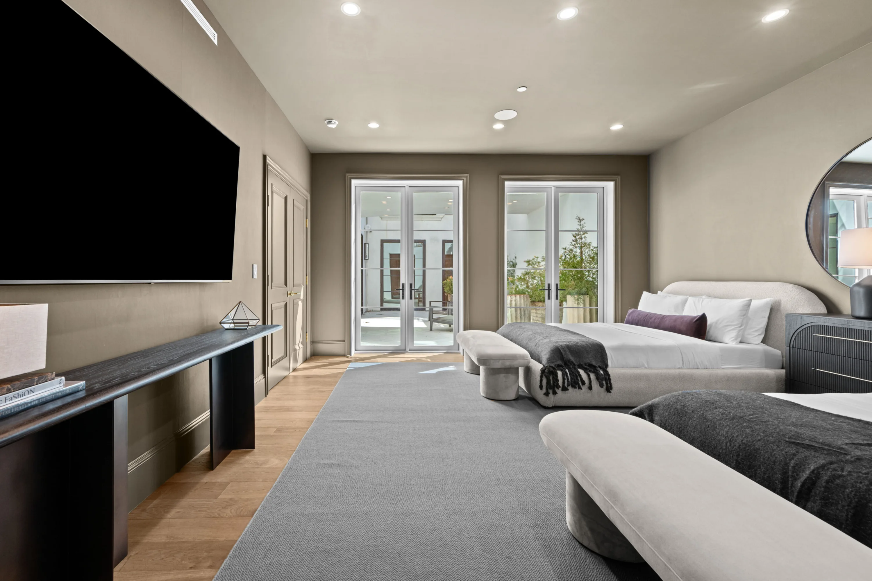 Wider view of the same double guest room, French doors opening onto a planted terrace