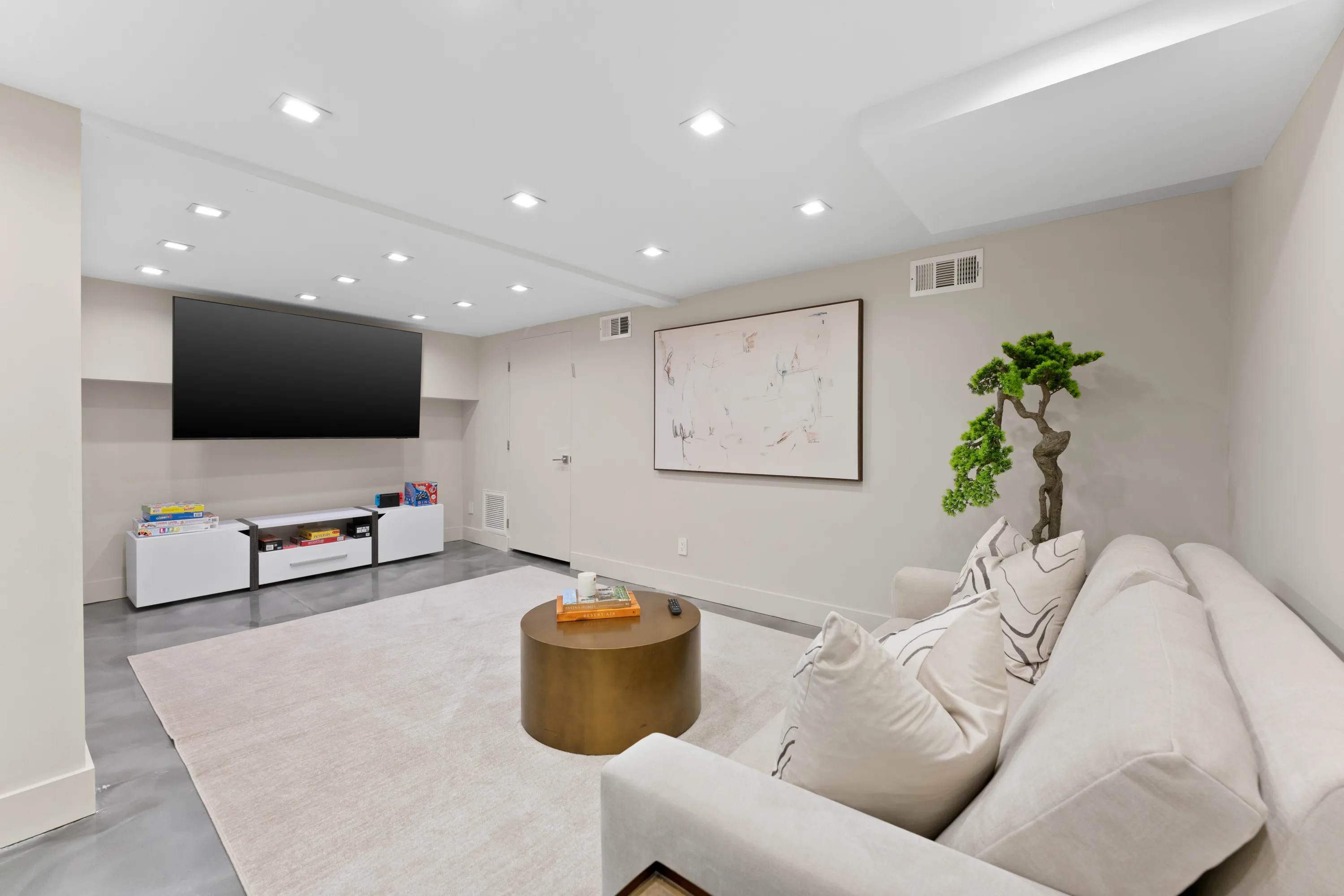 Spacious basement entertainment lounge at Rodeo Villa, a luxury Beverly Hills vacation rental featuring a pull-out sofa, game room, and comfortable seating.