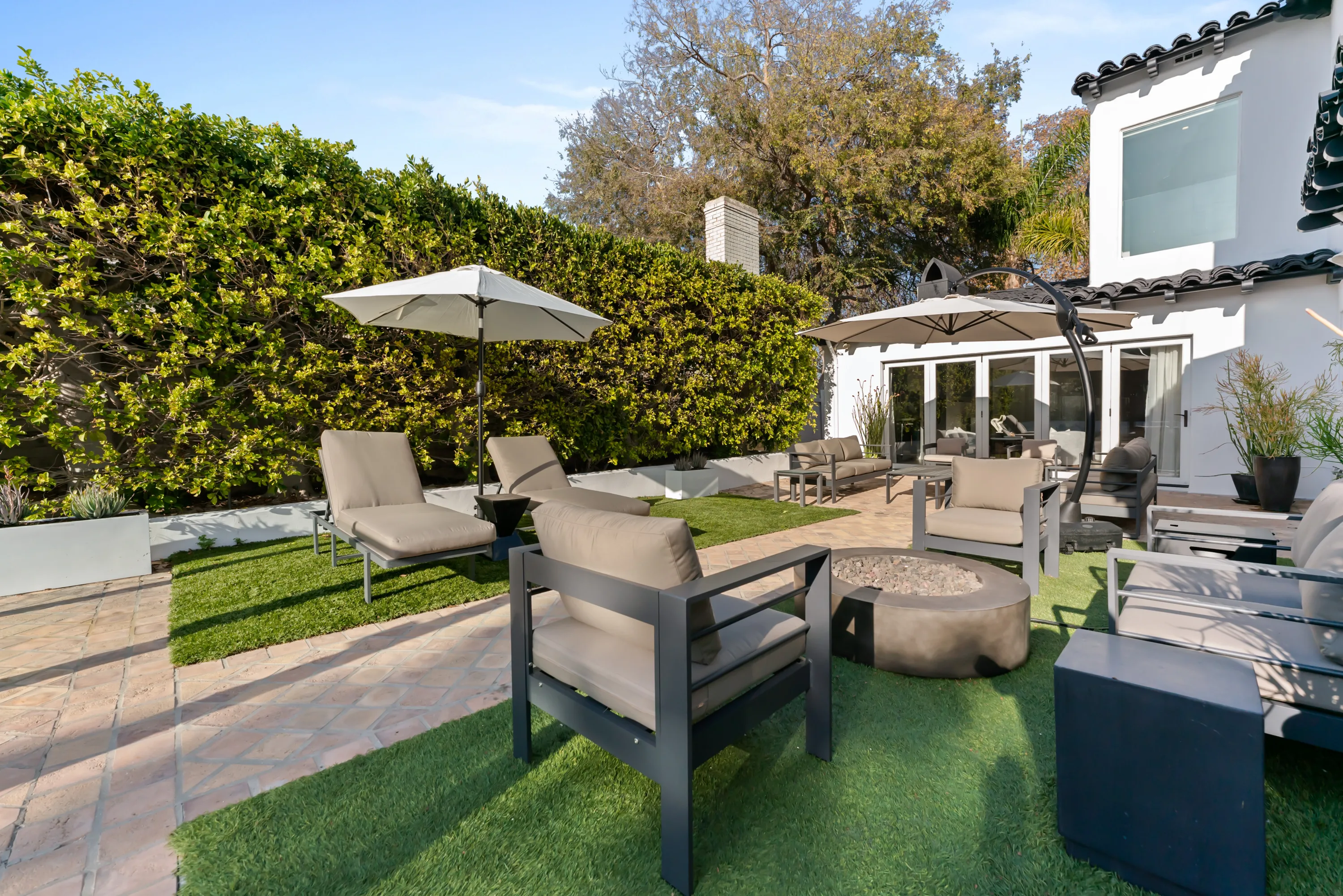 Private backyard at Rodeo Villa, a luxury Beverly Hills vacation rental featuring a fire pit, lounge seating, and a stylish outdoor space for relaxing or entertaining.