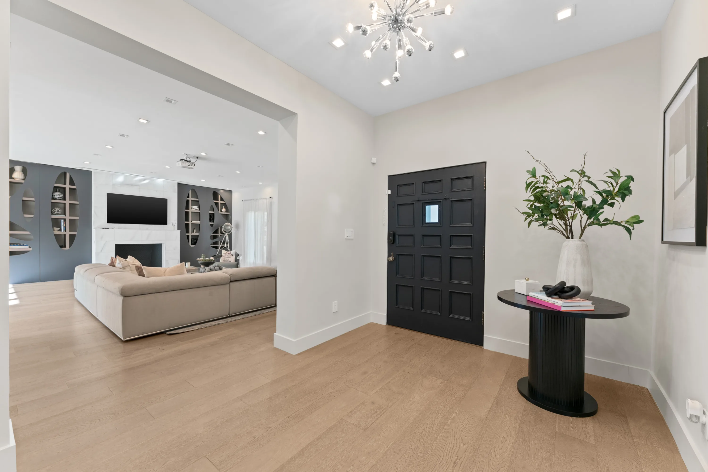 Elegant entryway at Rodeo Villa, a luxury Beverly Hills vacation rental featuring a statement chandelier, modern decor, and an open-concept living area.