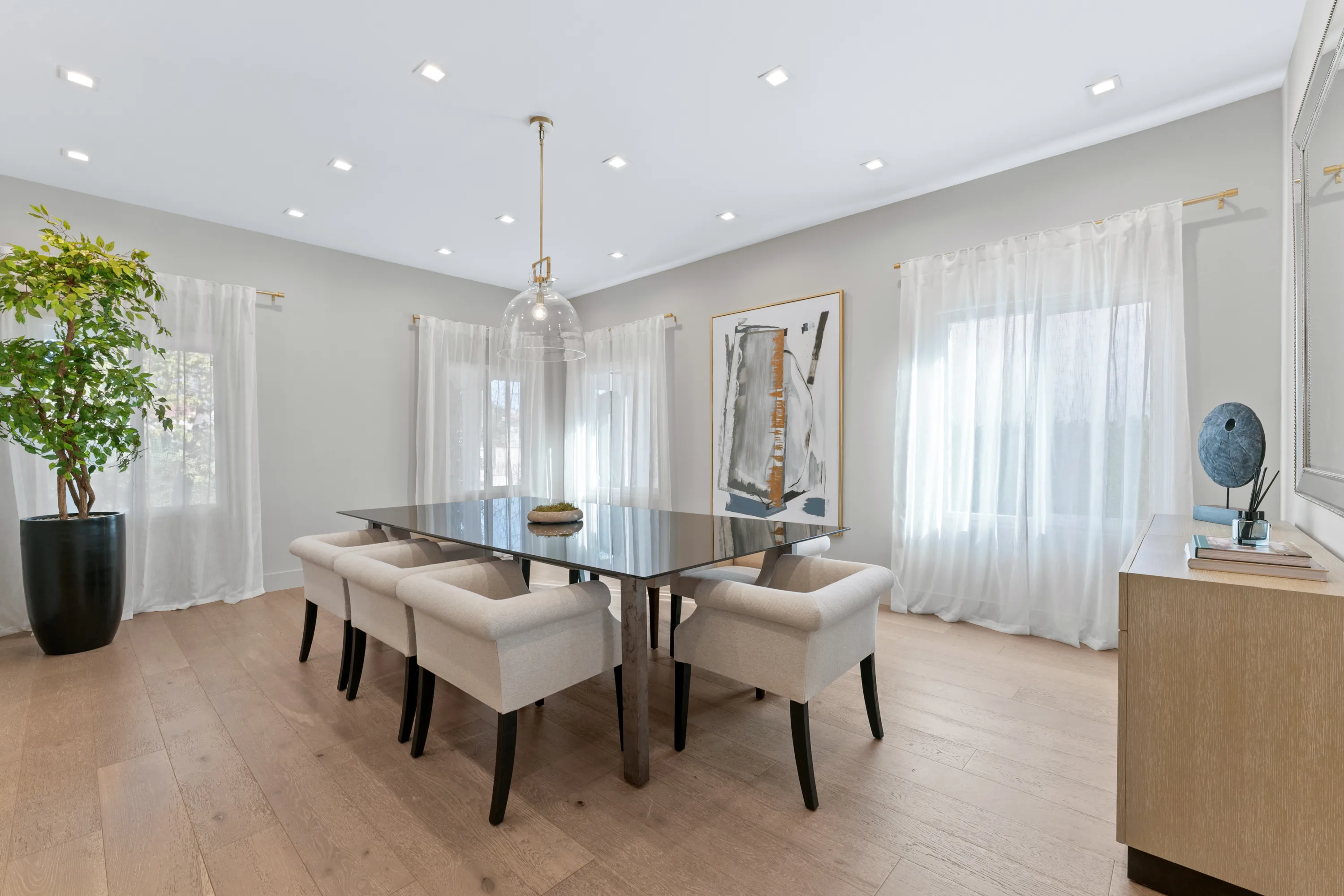 Elegant dining room at Rodeo Villa, a luxury Beverly Hills vacation rental featuring a modern dining table, upholstered chairs, and natural light.